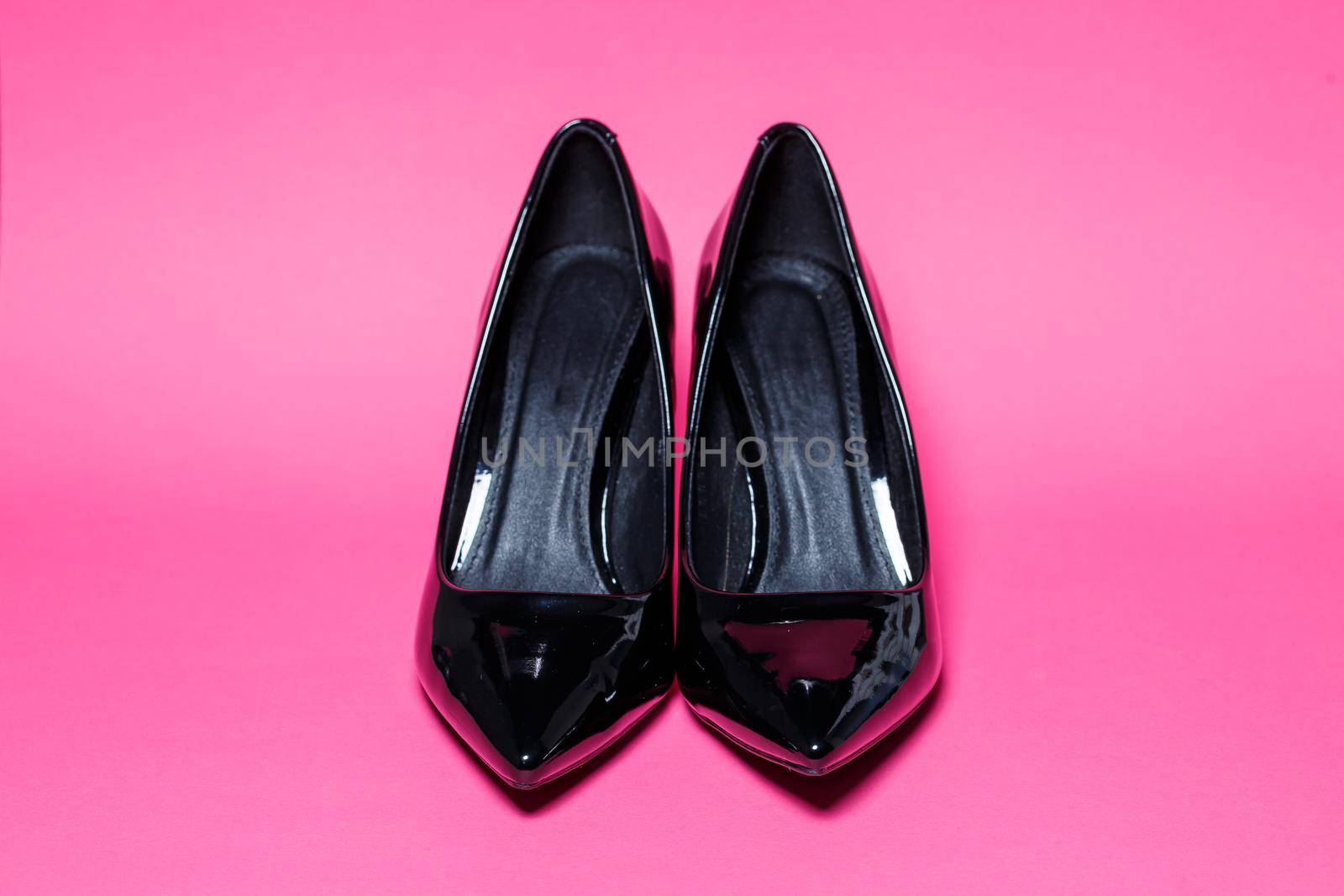 Black patent leather pumps on a colored background