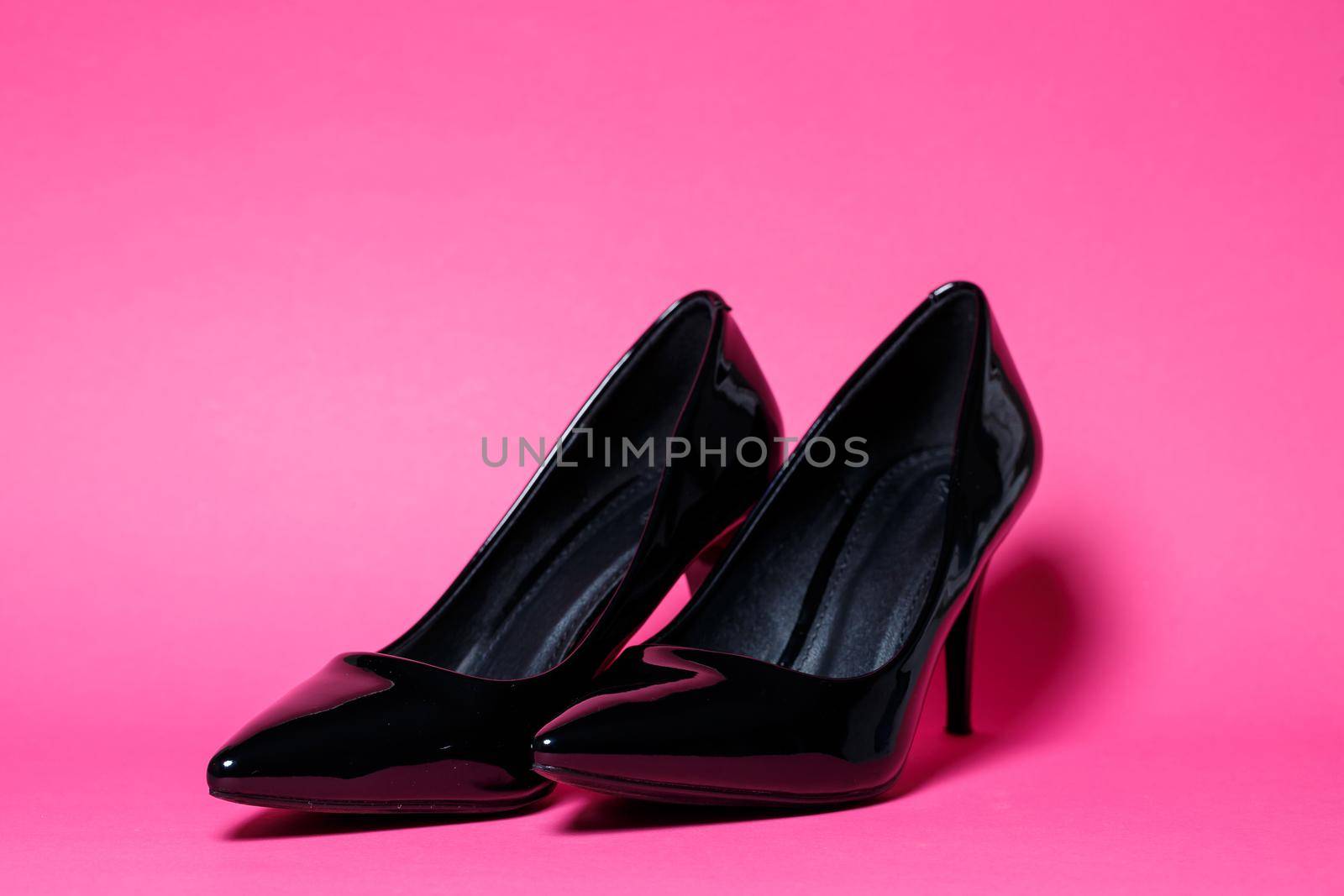 Black patent leather pumps on a colored background