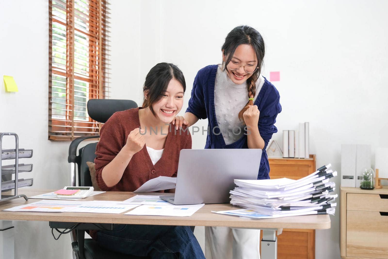 Two asian woman celebrating victory, won profitable contract, unexpected amazing win, big deal on stock, impressive achievement, unbelievable success