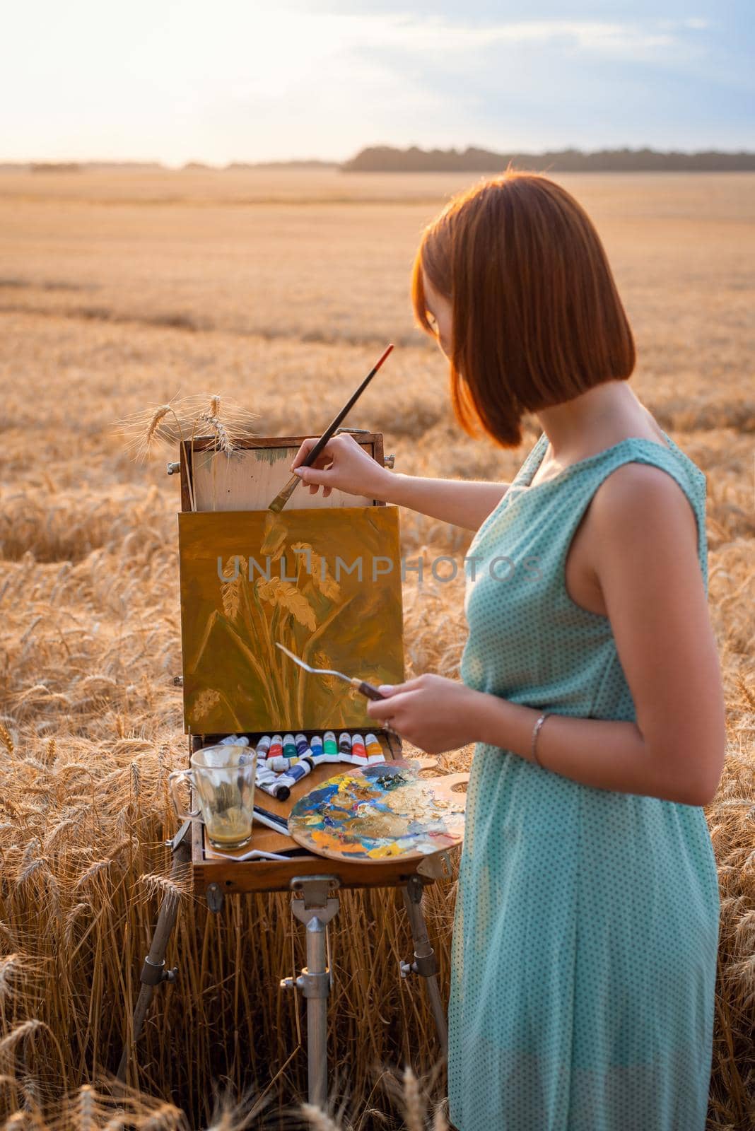 Box easel with canvas, oil paints, palette, and tools of an artist