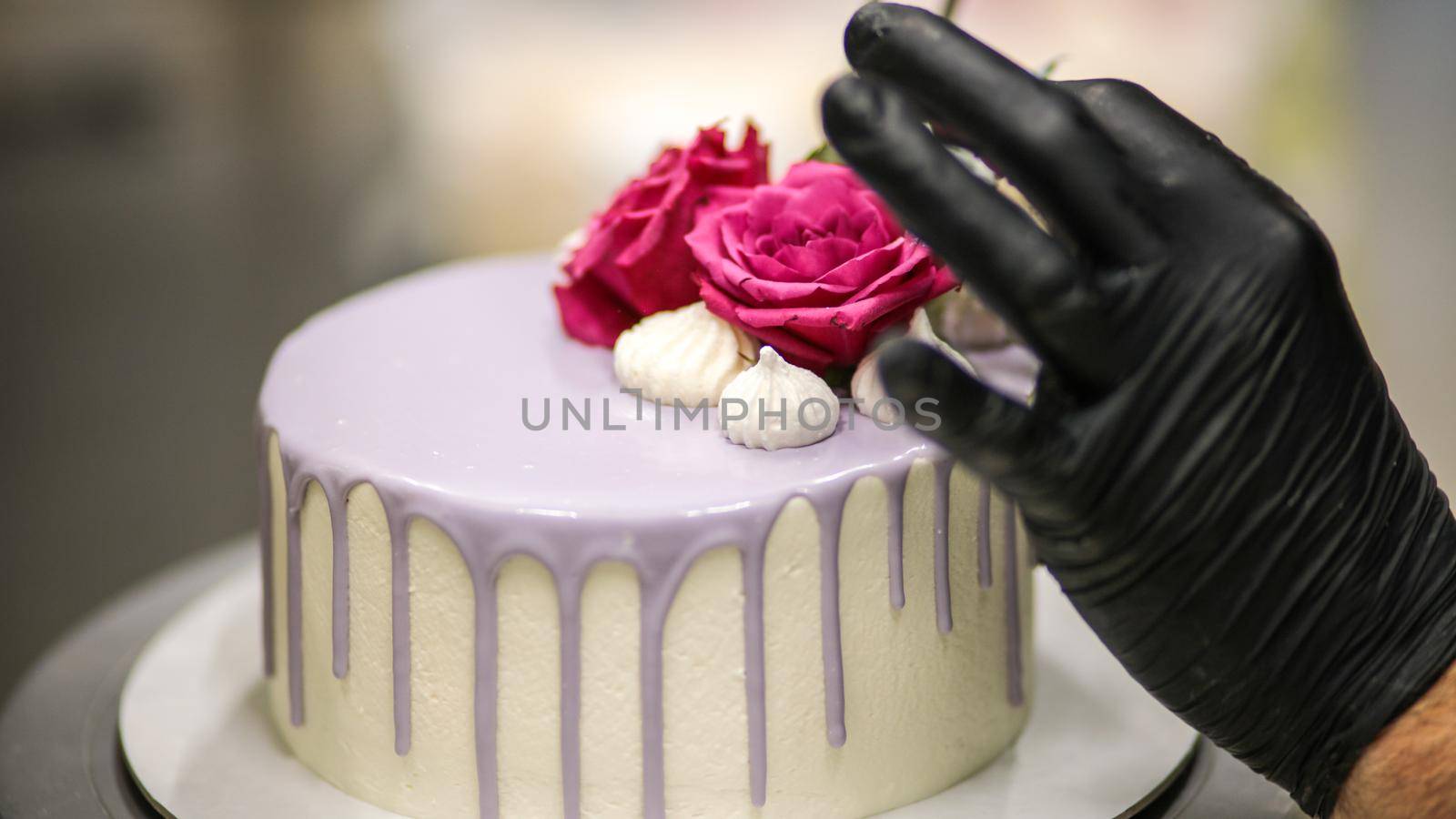 chef usign macaron , flowers and text sign for a celebration cake