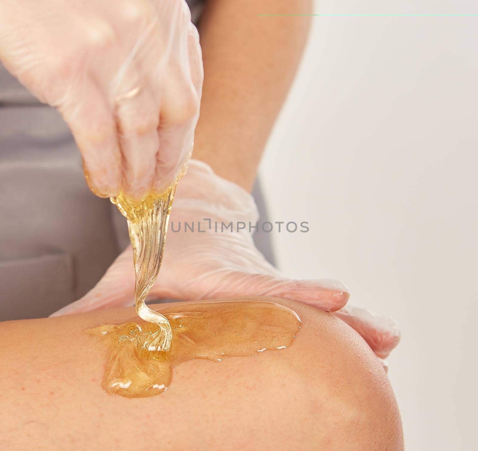 Sugar paste for light depilation. Depilation with sugar paste in the salon on a white background.