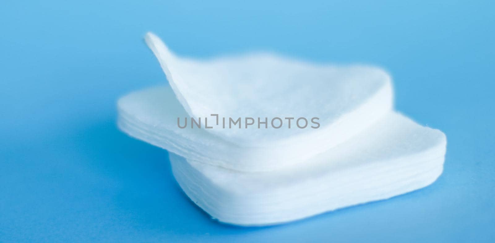 Cosmetology, cleanliness and branding concept - Organic cotton pads on blue background, cosmetics and make-up remover, hygiene and skincare beauty brand product for healthcare and medical design