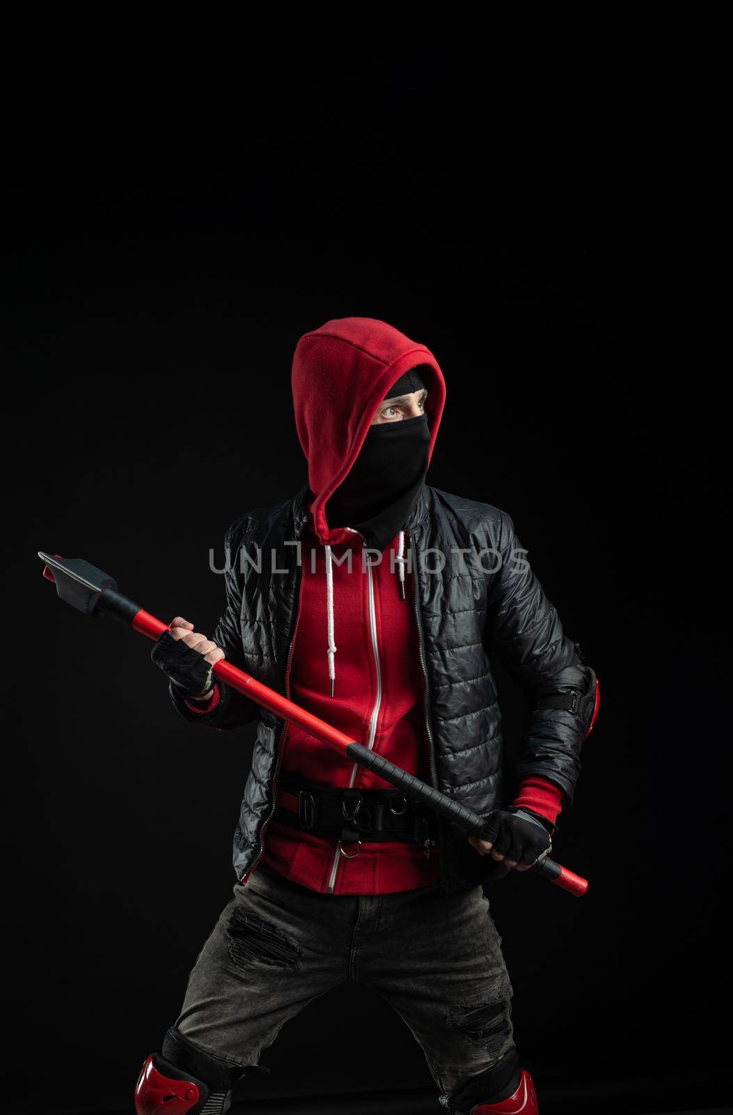 a man in a Balaclava and hoodie with an axe the image of a Protestant by Rotozey