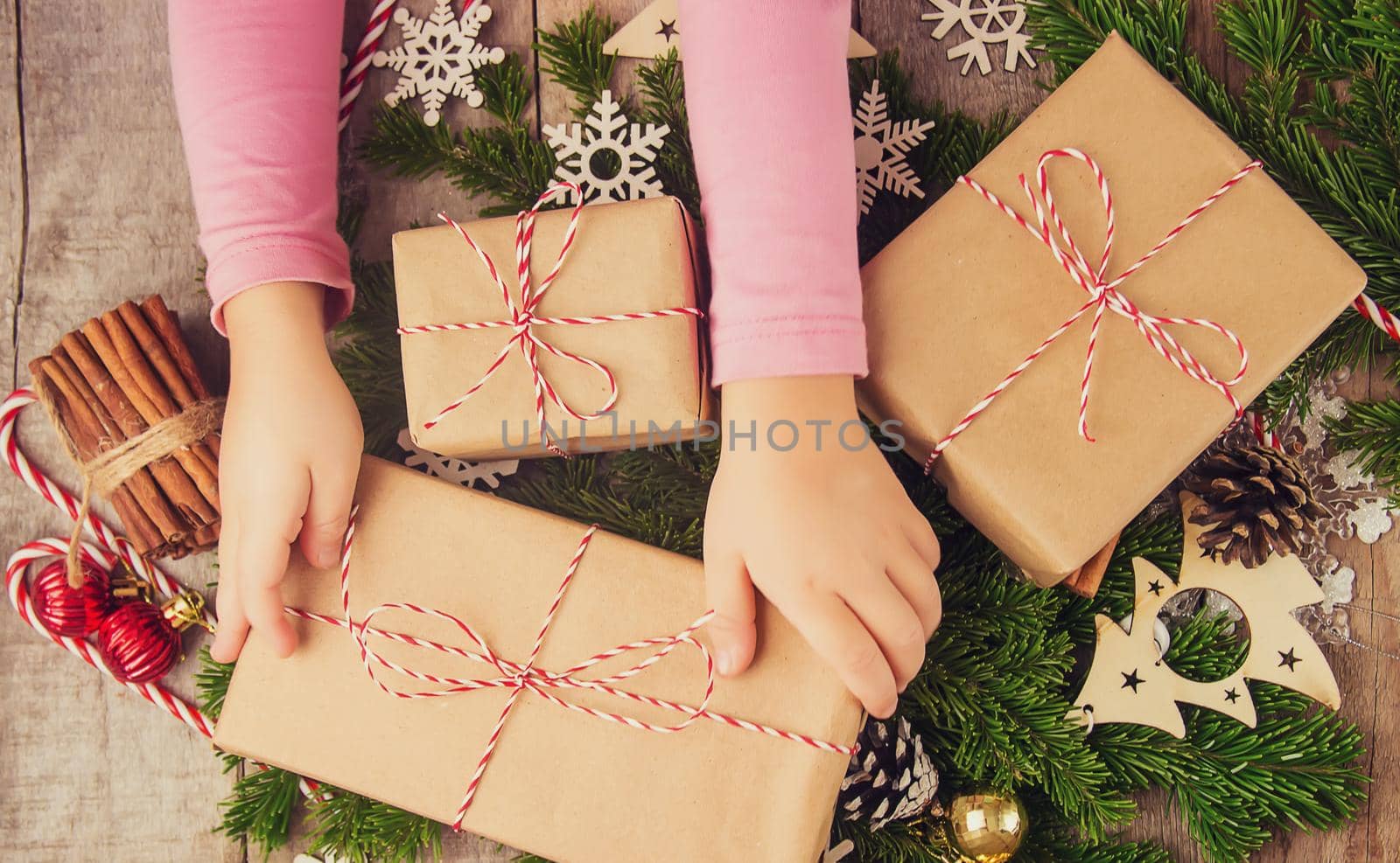 Child holds a Christmas decor and gifts on a white background. Selective focus. by yanadjana