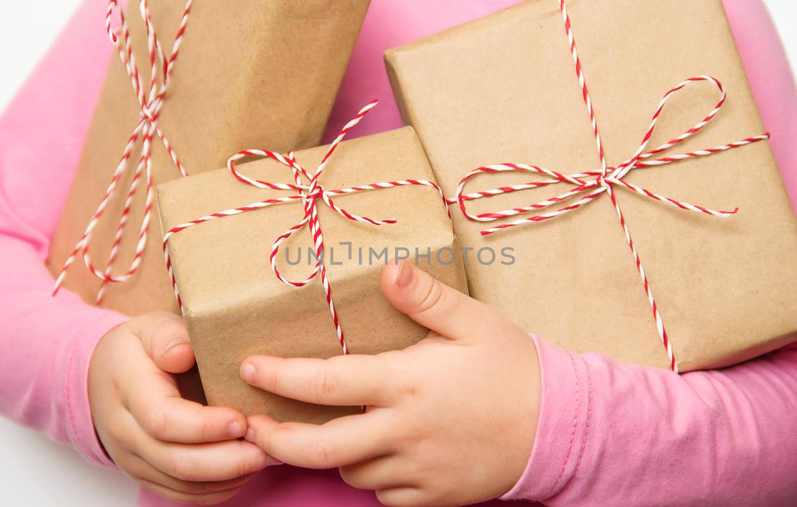 Child holds a Christmas decor and gifts on a white background. Selective focus. Happy.