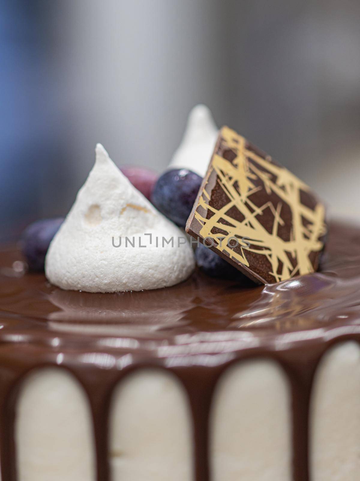 unrecognizable worker preparing a sweet dripping choco cake and berries