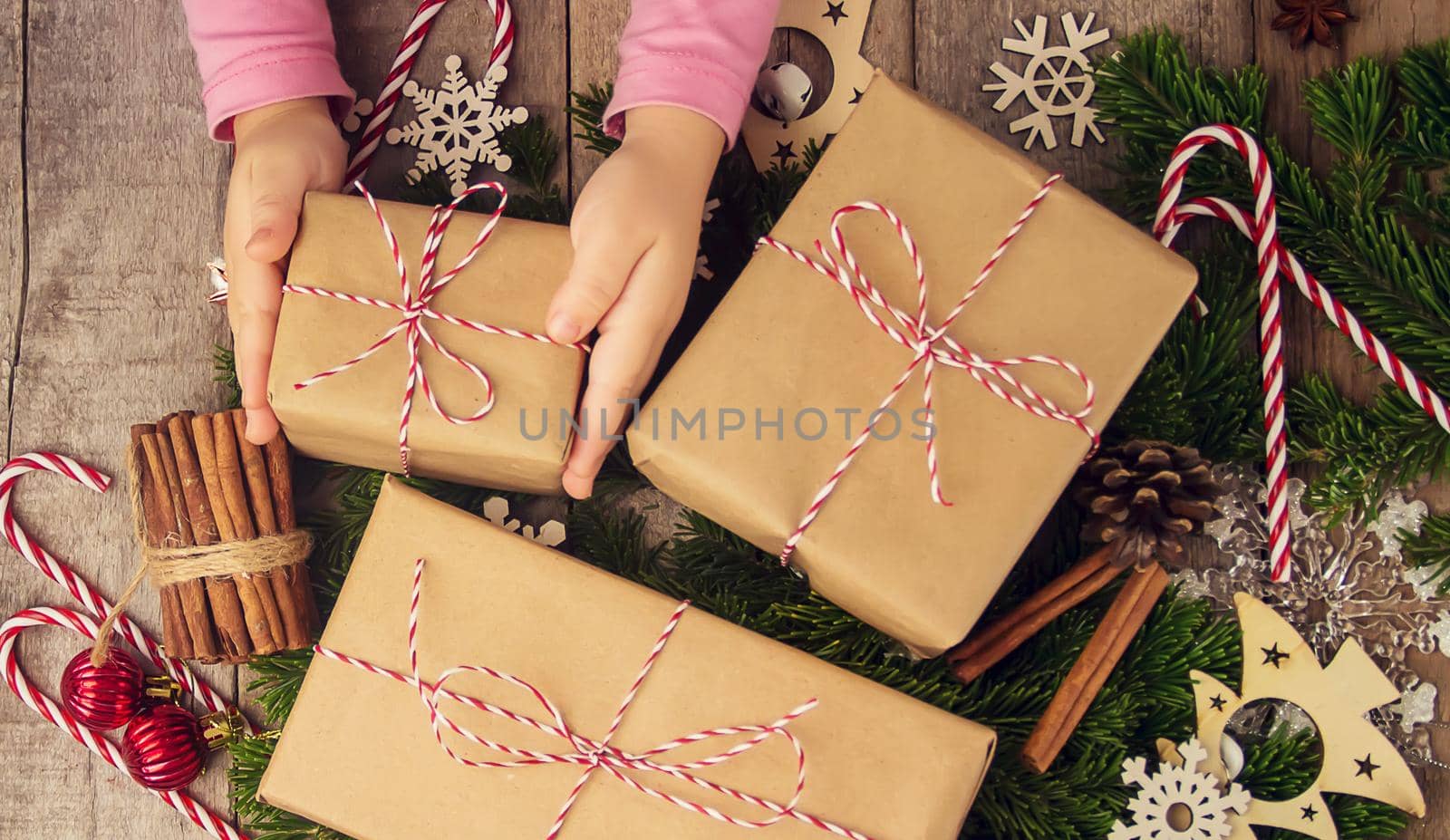 Child holds a Christmas decor and gifts on a white background. Selective focus. Happy.