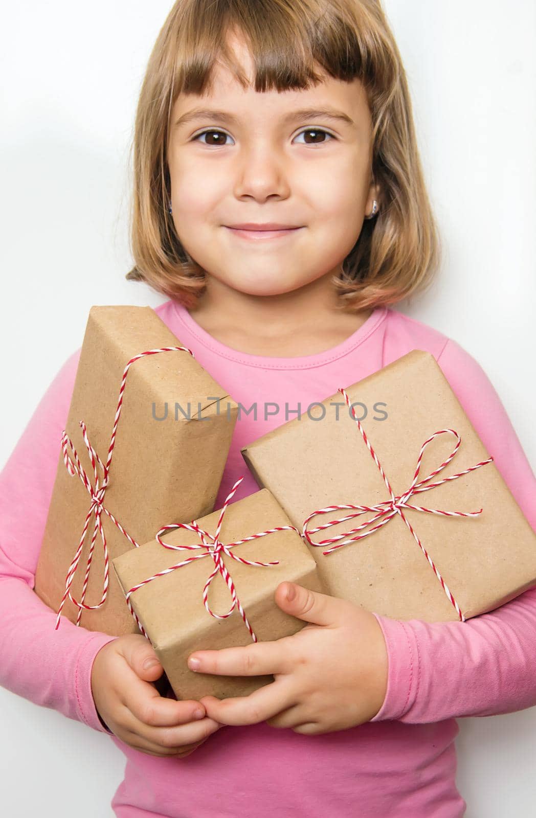 Child holds a Christmas decor and gifts on a white background. Selective focus. Happy.