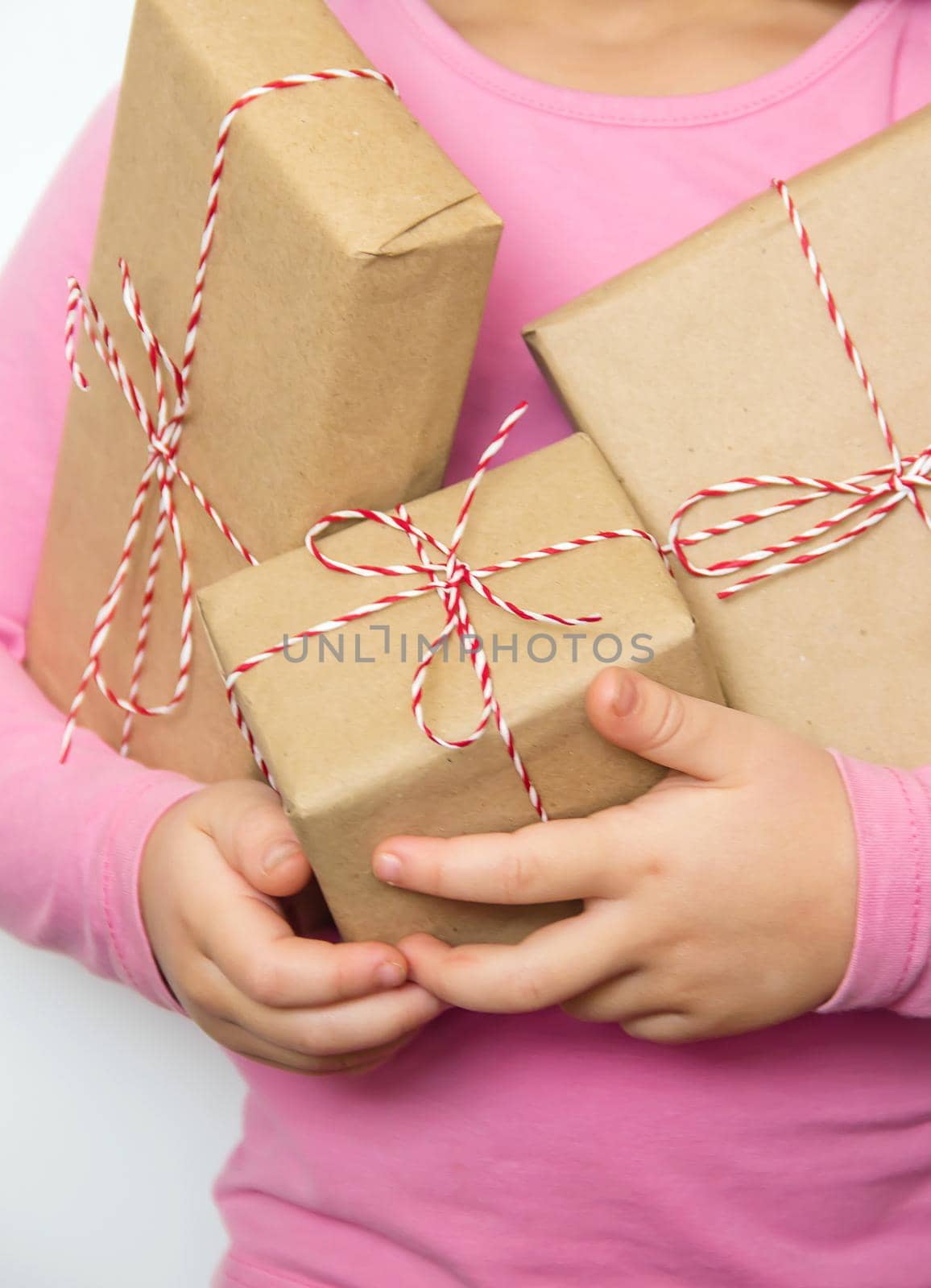 Child holds a Christmas decor and gifts on a white background. Selective focus. Happy.