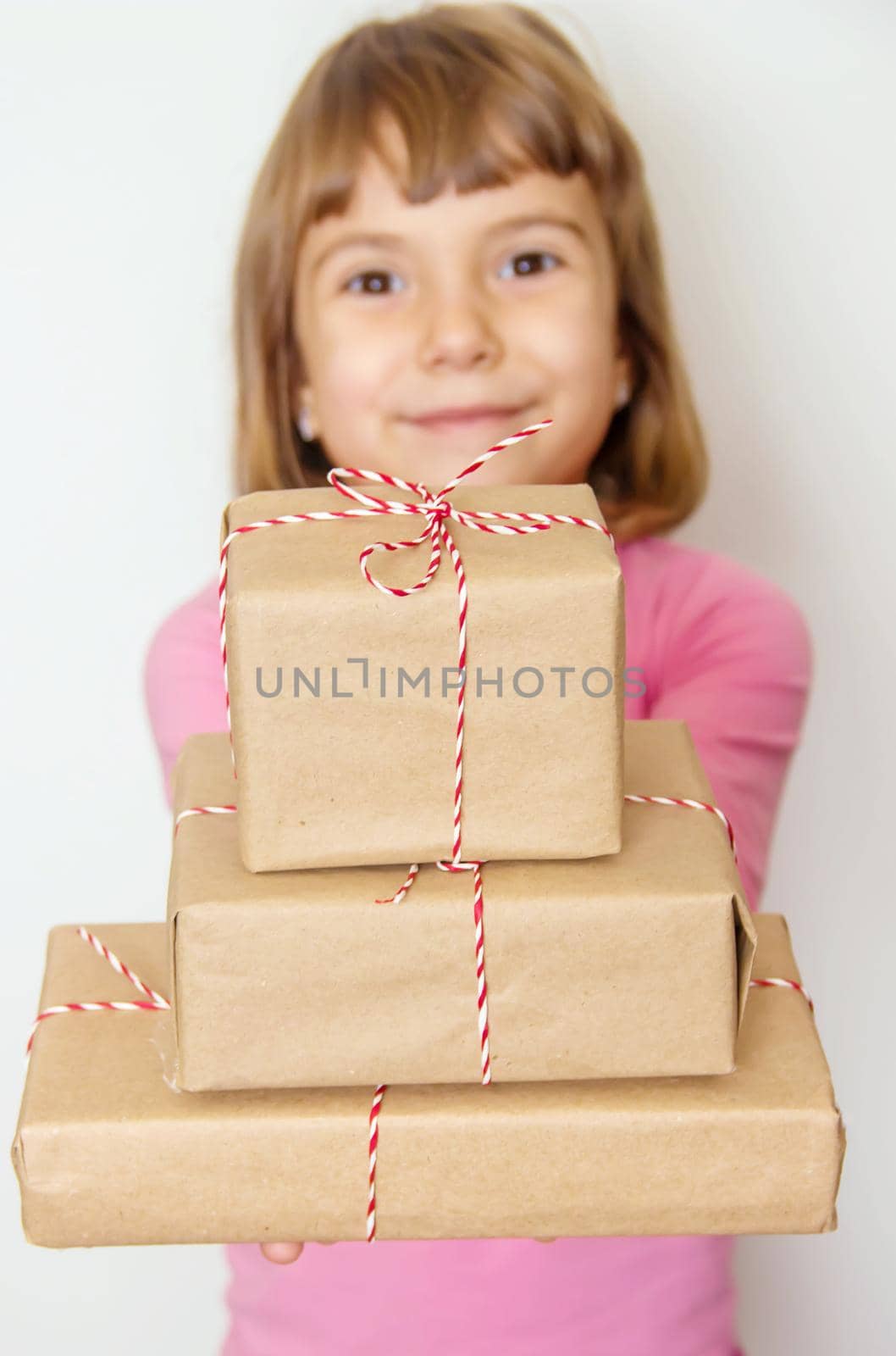 Child holds a Christmas decor and gifts on a white background. Selective focus. Happy.