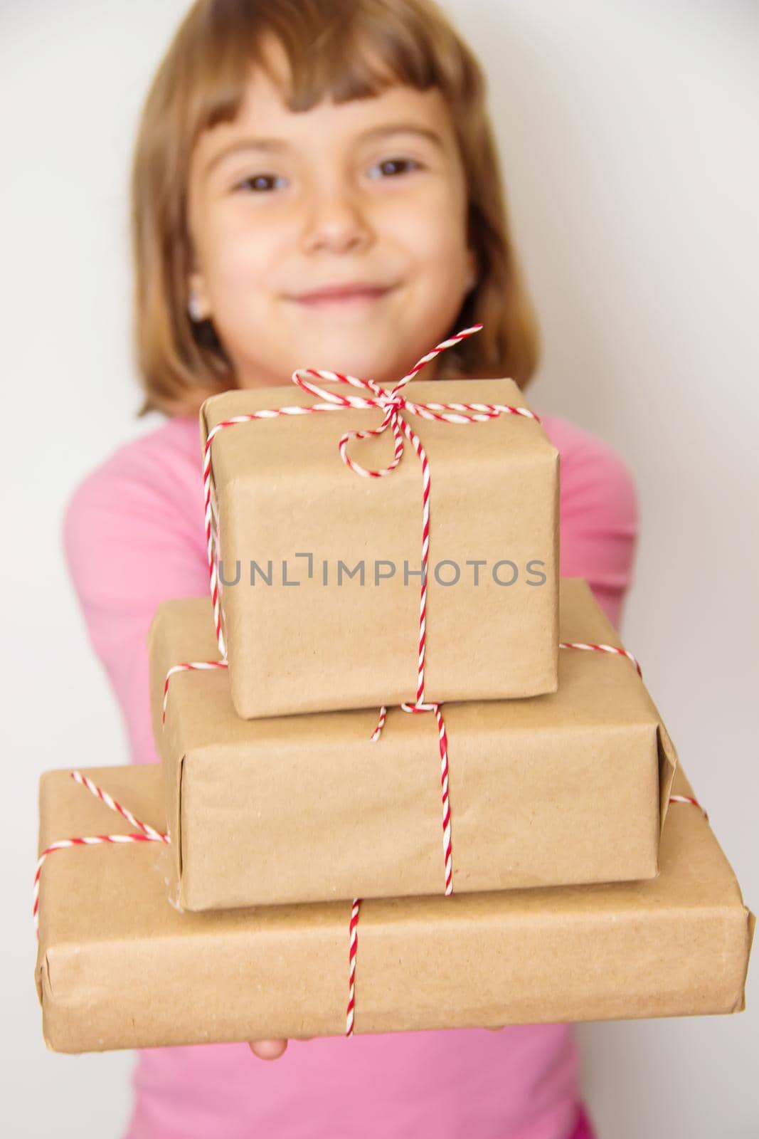 Child holds a Christmas decor and gifts on a white background. Selective focus. by yanadjana