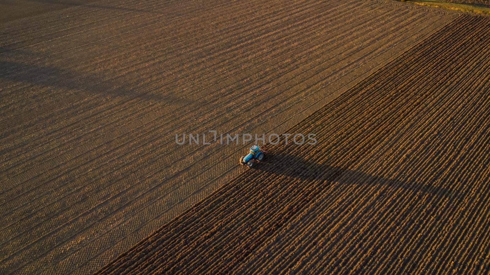 farmer with tractor leveling land in the countryside.