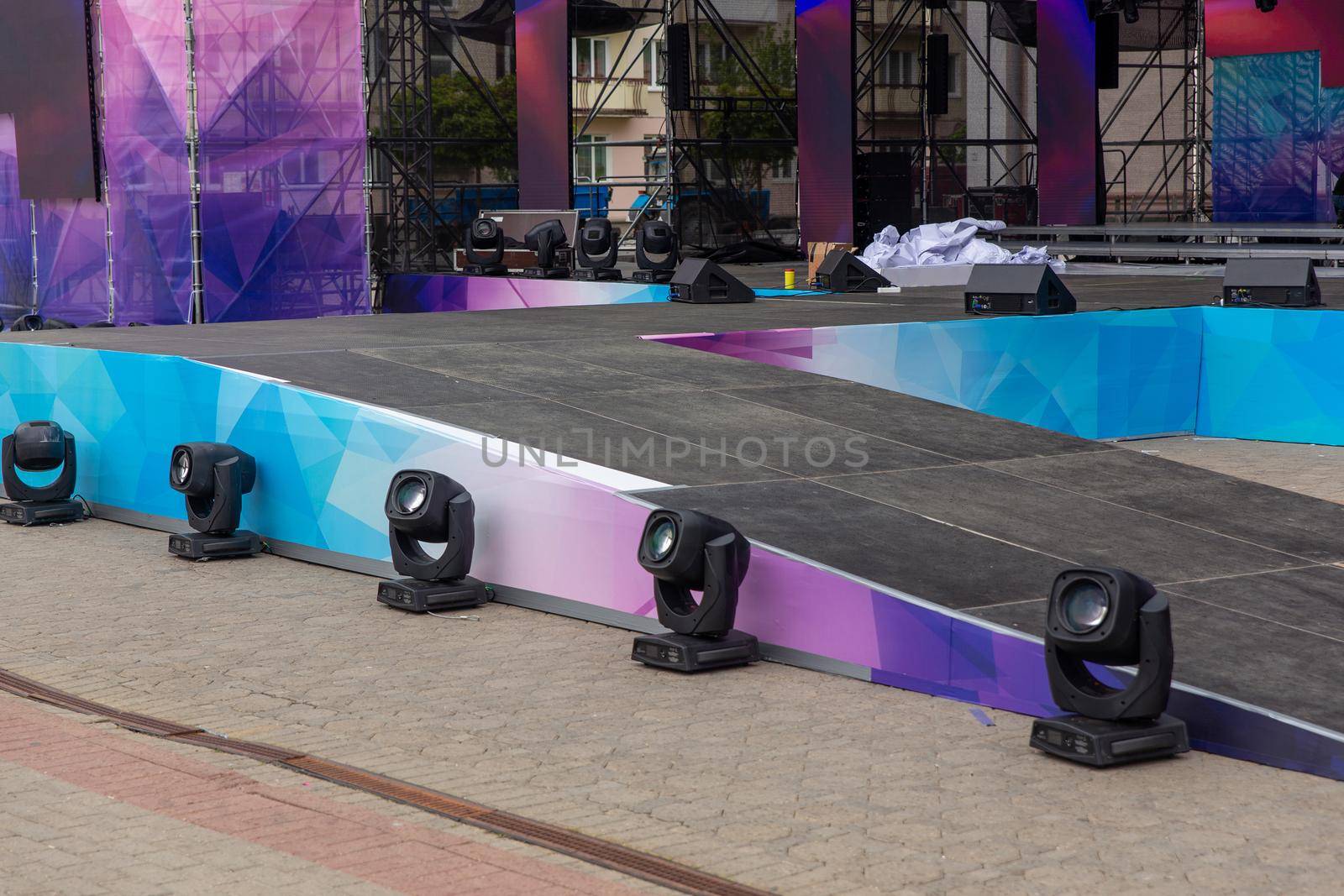 Professional lighting equipment installed at the bottom of the outdoor concert scene. Lighting equipment with spotlights and floodlights under the scene.