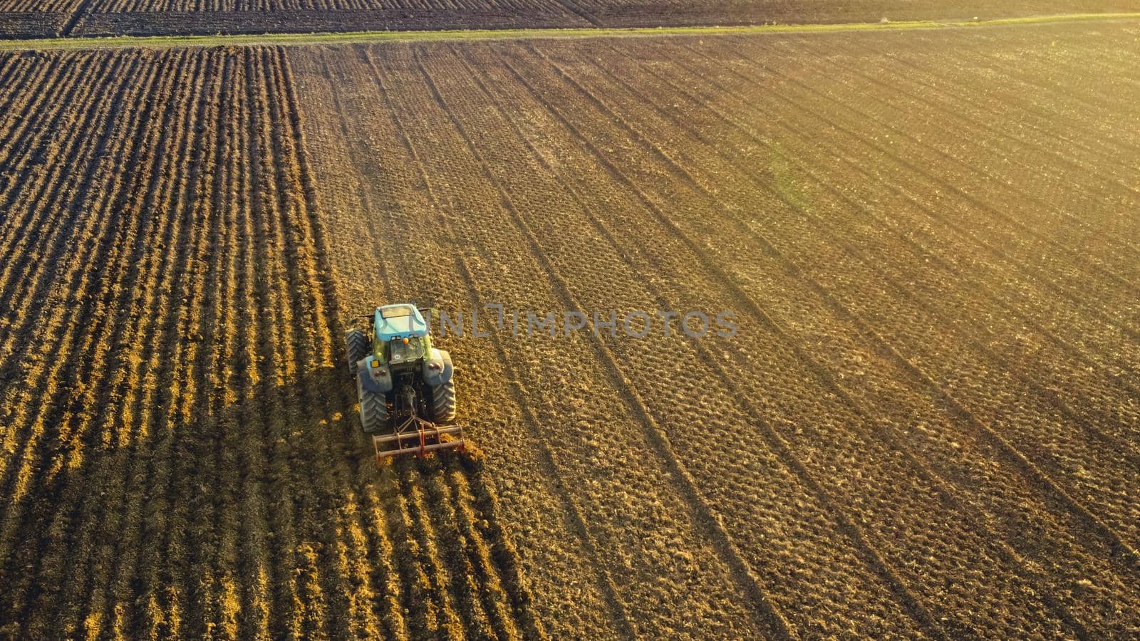 farmer with tractor leveling land in the countryside.