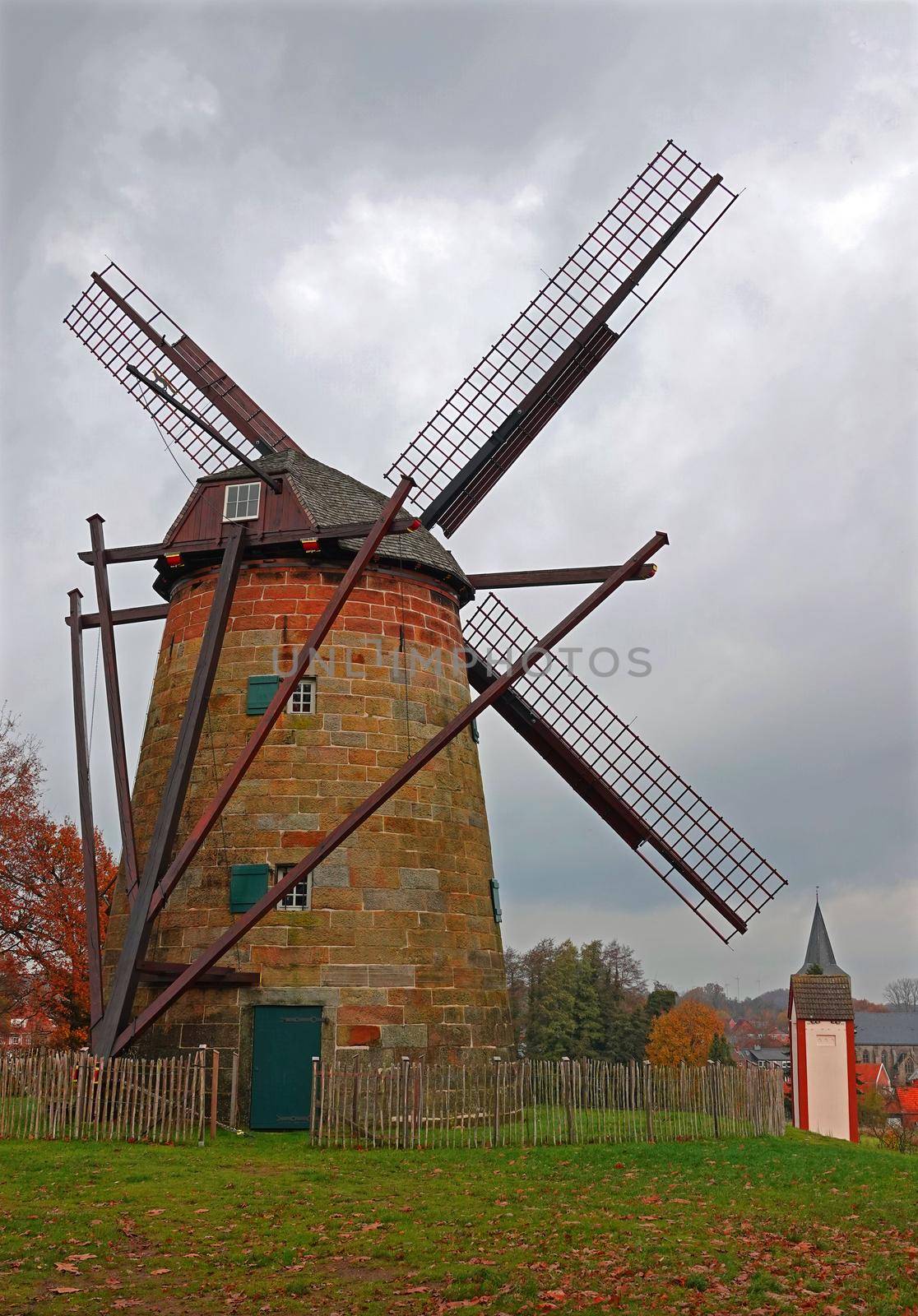 Historical dutch windmill in Uelsen, Germany in autumn. It's a smock windmill from the 18th century, made from yellow sandstone. Location: Uelsen, Germany