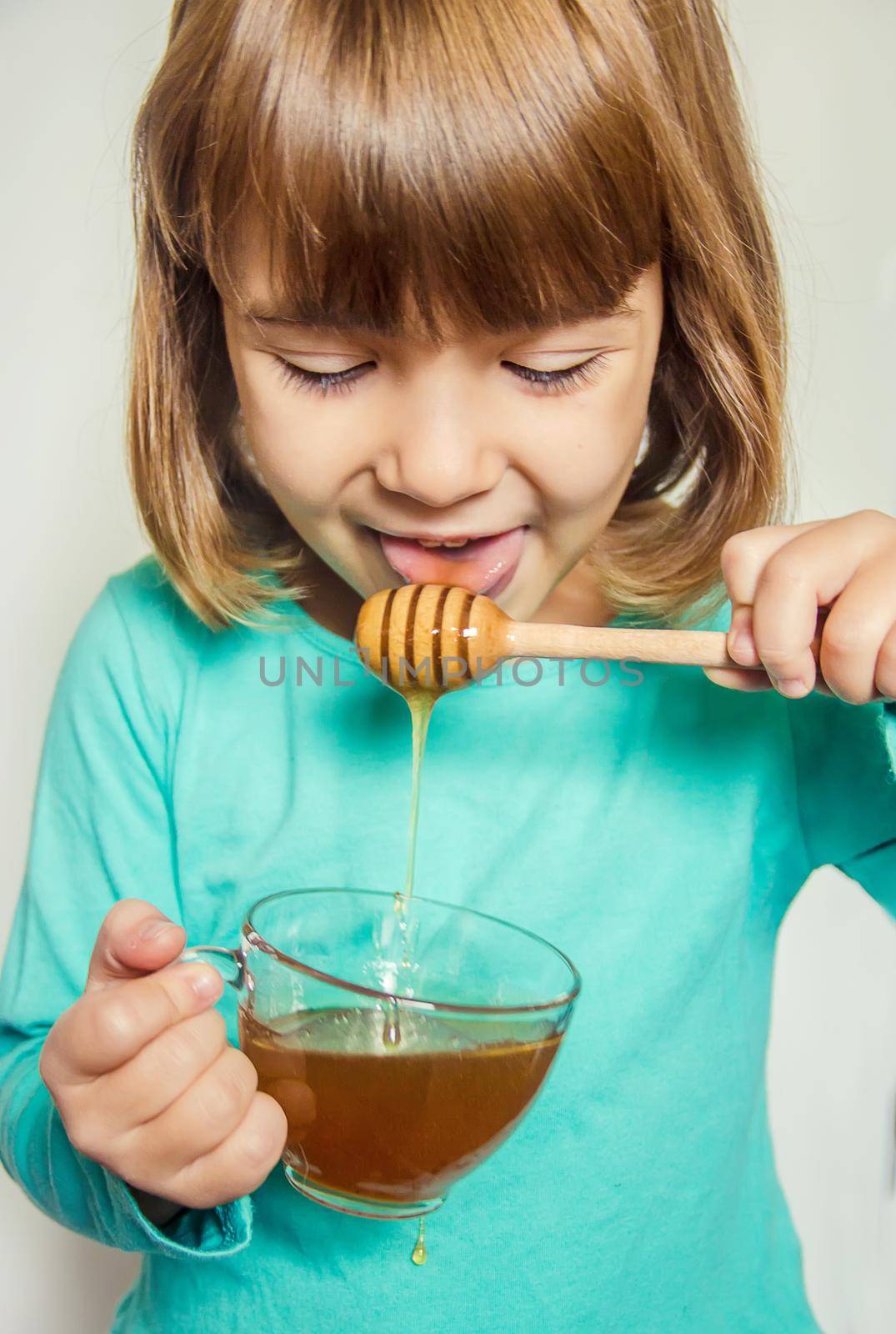 The child eats honey. Selective focus. nature by yanadjana