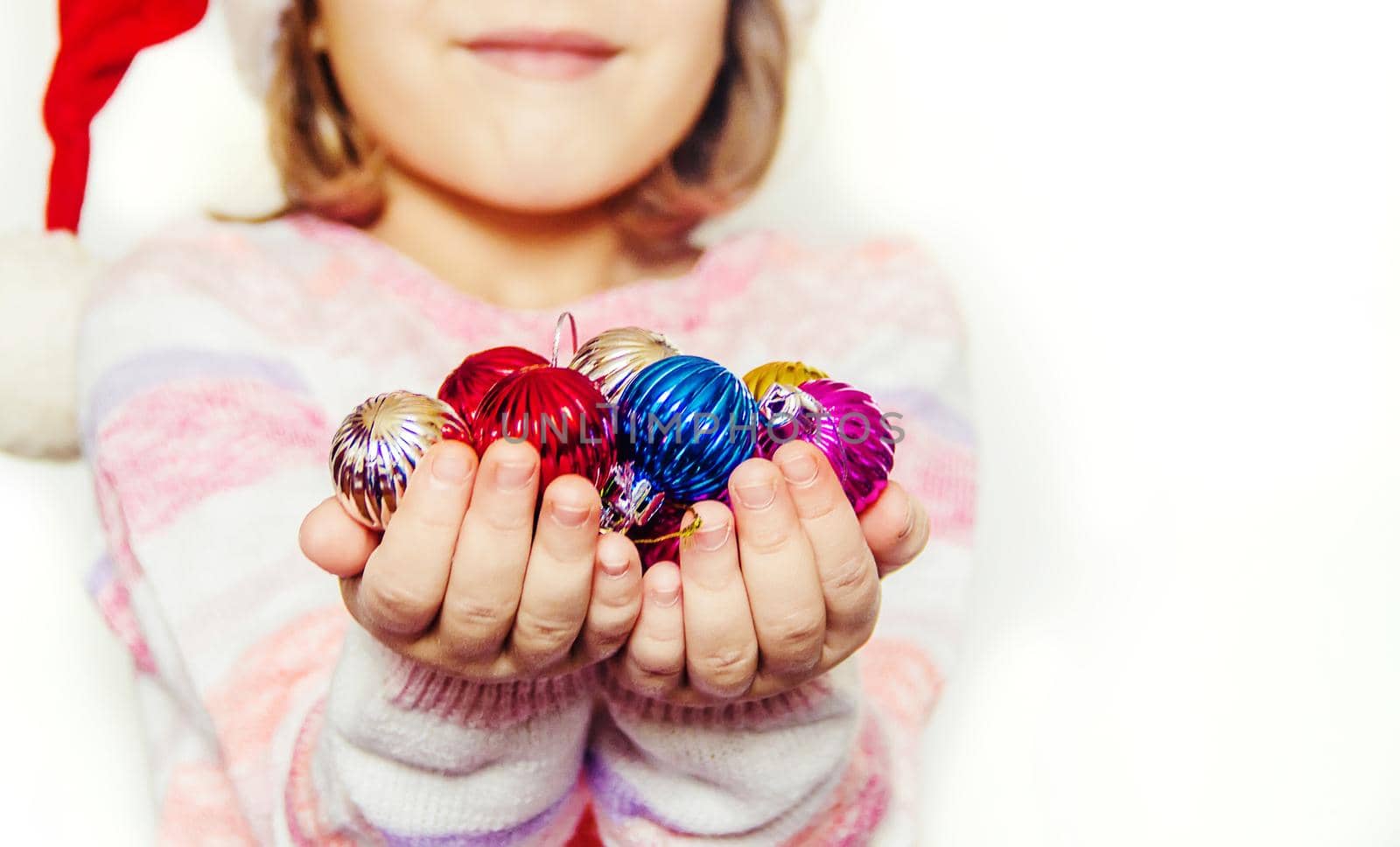Child holds a Christmas decor and gifts on a white background. Selective focus. by yanadjana