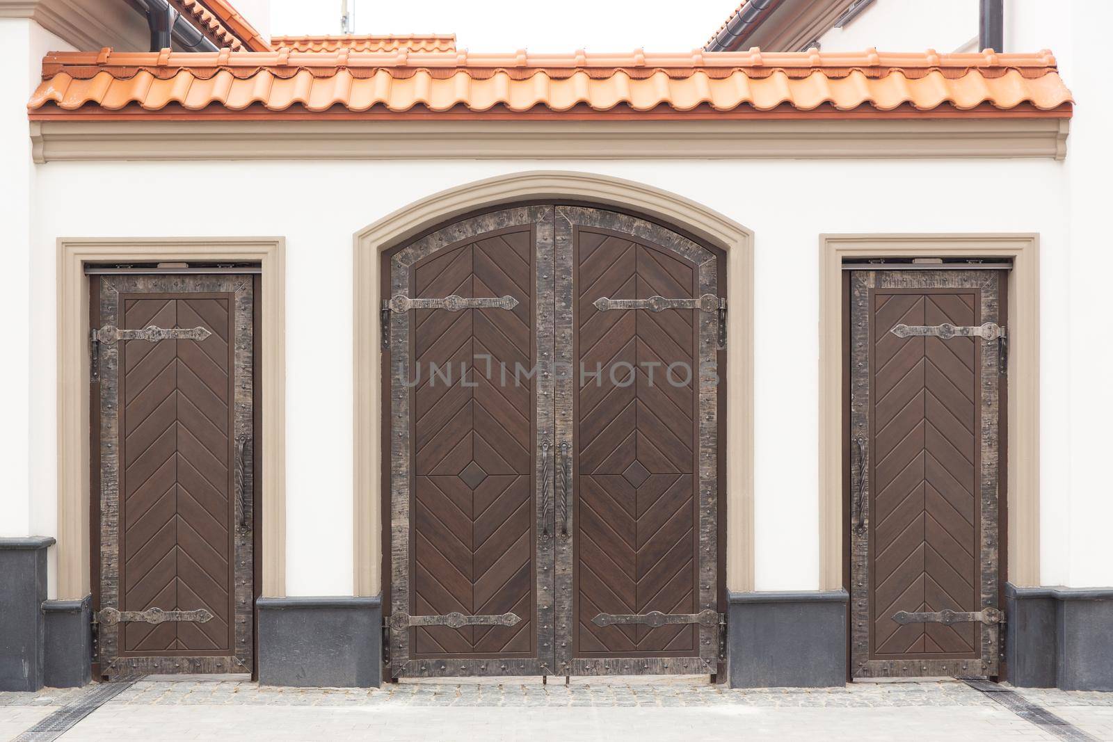 European house exterior vintage detail. Wooden gates and doors with forged elements on building in retro style in Belarus.