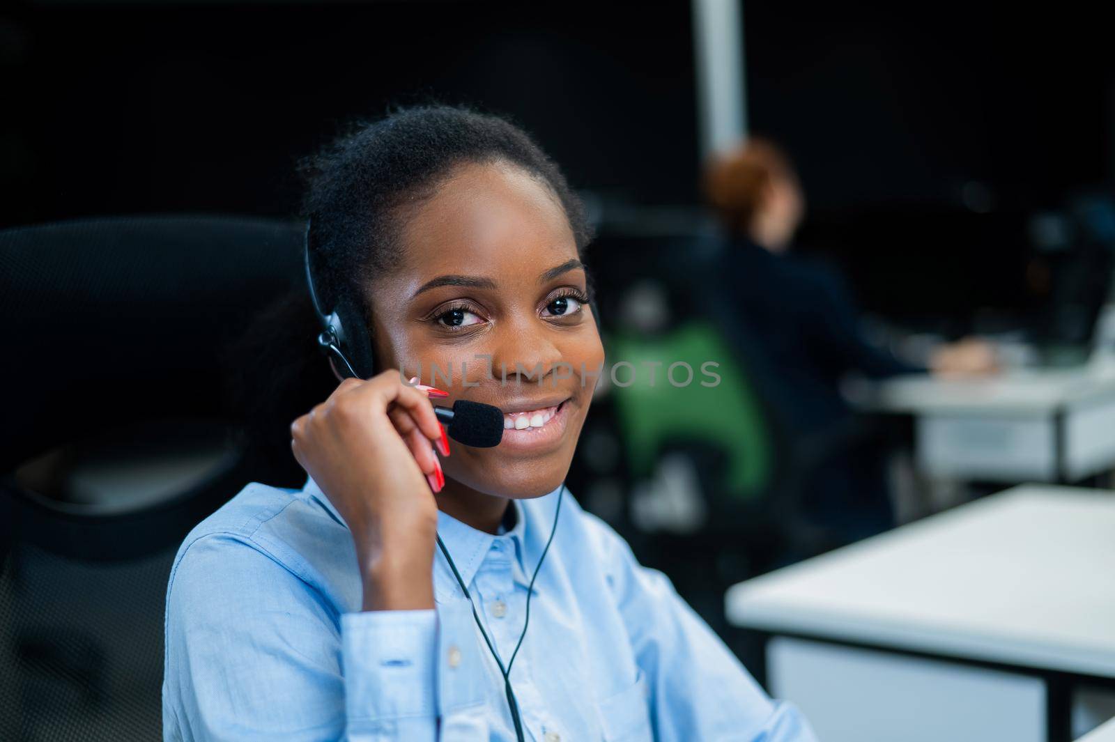 African young woman talking to a client on a headset. Female employee of the call center. by mrwed54