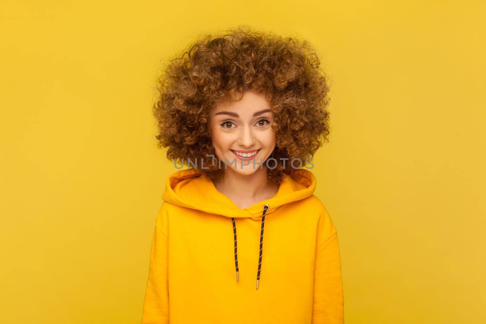 Happy woman with Afro hairstyle looking at camera with cute positive face, being in good mood. by Khosro1