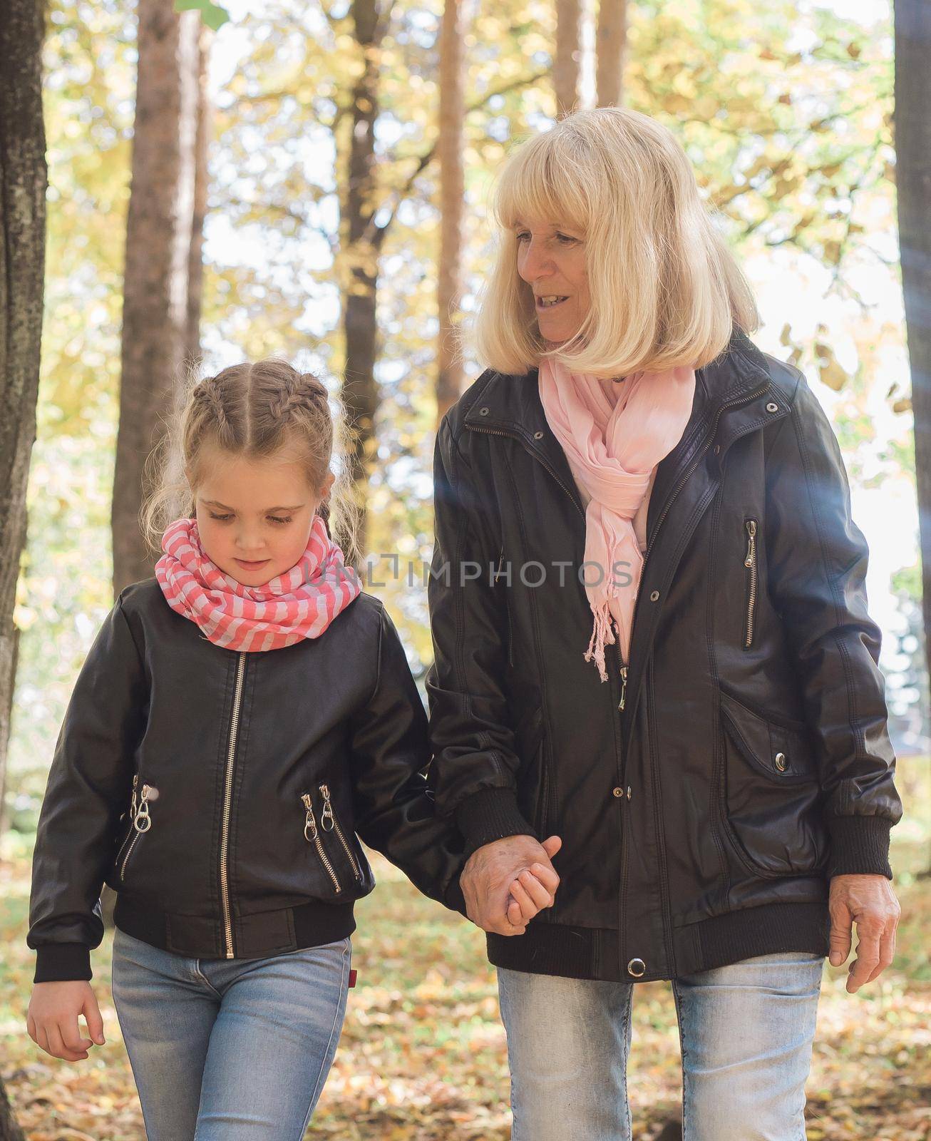 Grandmother with granddaughter in autumn park. Generation and family concept. by Satura86