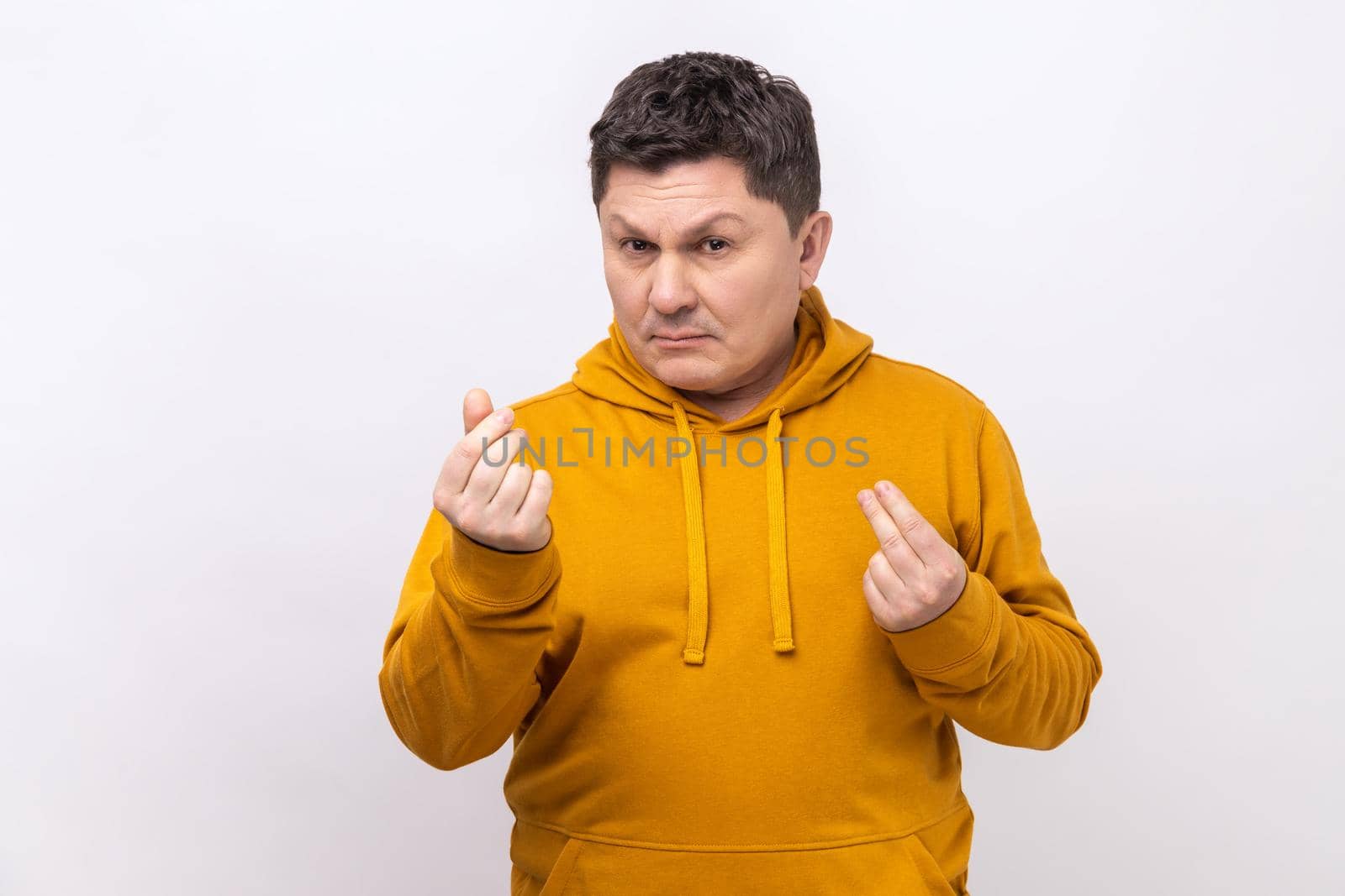 Portrait of handsome middle aged man standing and looking at camera with money or italian gesture with hand, wearing urban style hoodie. Indoor studio shot isolated on white background.