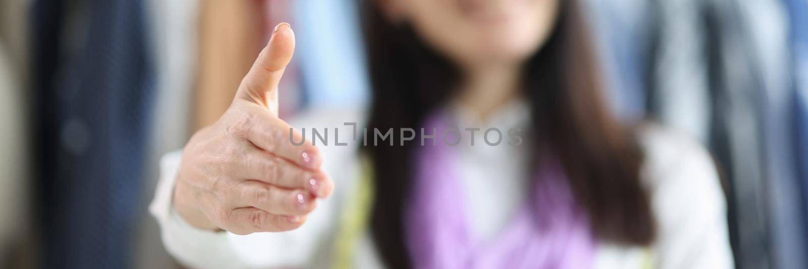 Woman seamstress holds out hand for handshake closeup by kuprevich