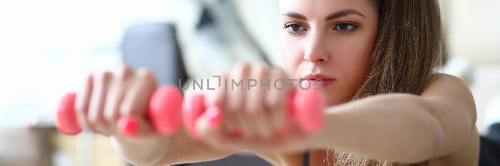 Portrait of young lying woman with dumbbells by kuprevich