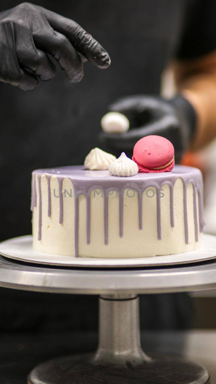 chef usign macaron , flowers and text sign for a celebration cake
