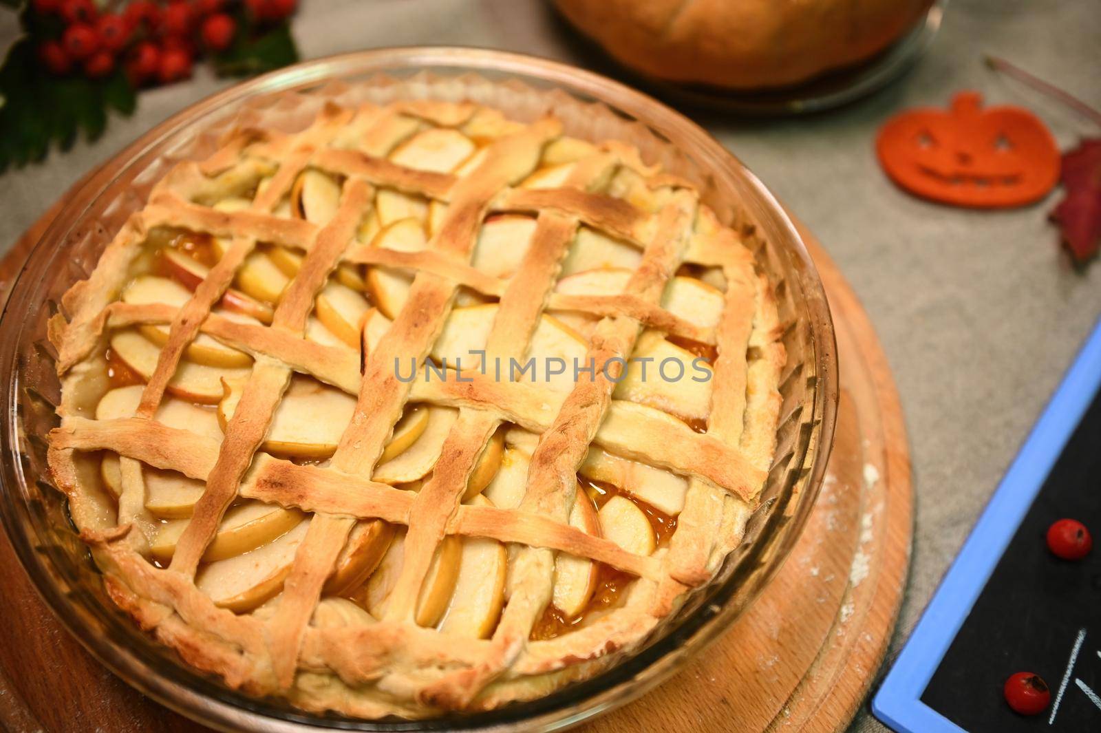 Homemade delicious yummy festive pumpkin pie with caramelized apples, with flaky crust lattice for Thanksgiving dinner. by artgf