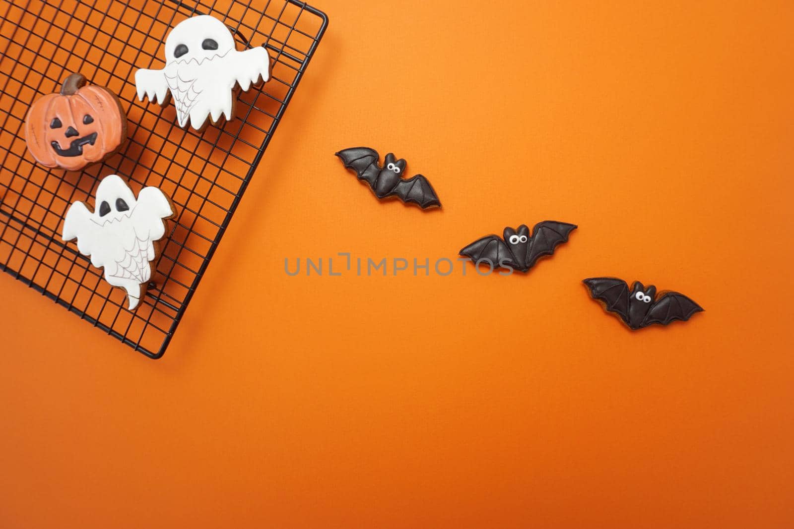 Halloween gingerbread cookies are on an orange background by Spirina