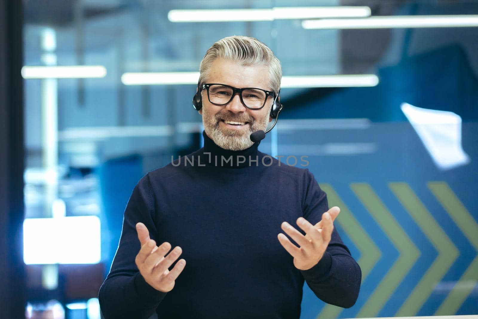 Online training. A man in headphones with a microphone conducts an online meeting, webinar on camera by voronaman