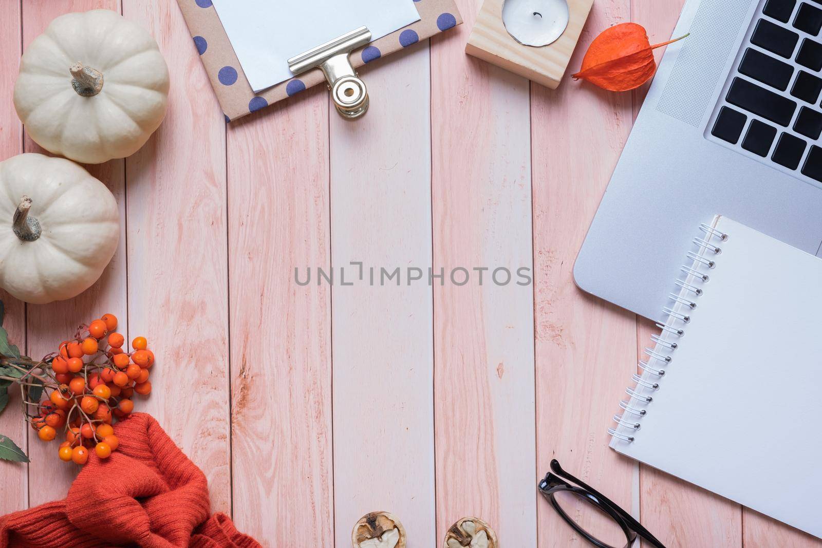 Desktop with note and laptop and autumn cozy decor with copy space on wooden background, flat lay. Top view. High quality photo