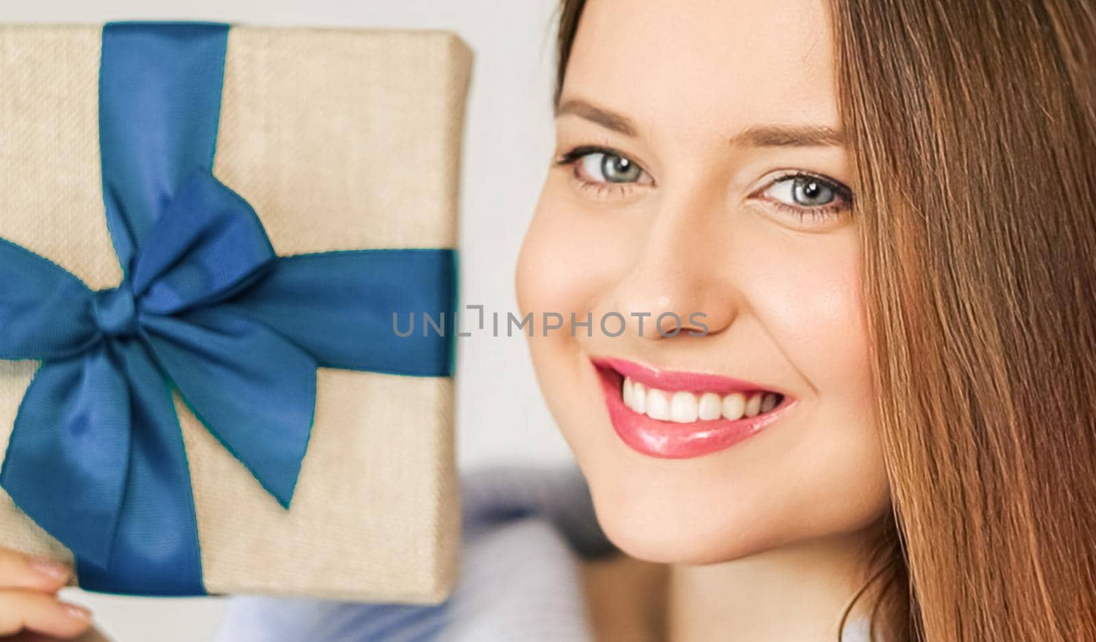 Winter holidays, present and Merry Christmas concept, happy woman smiling and holding wrapped gift box, close-up portrait