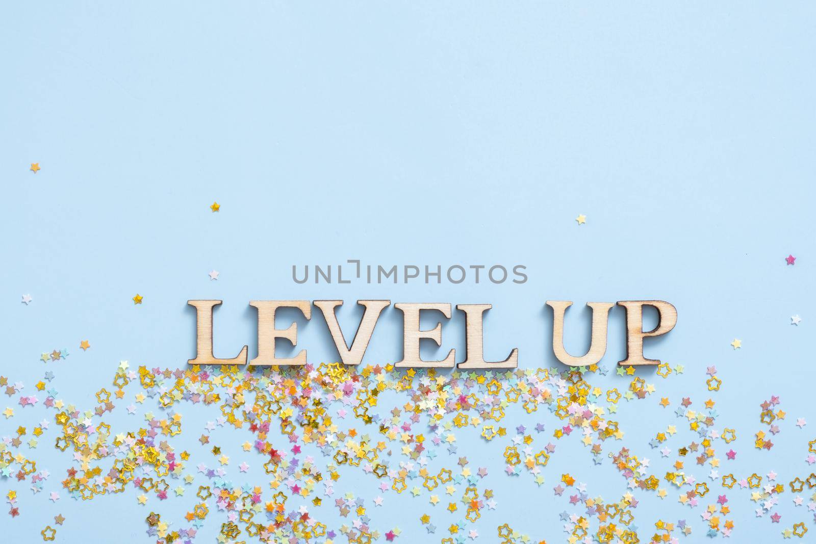 Level up wooden inscription on a colored background with stars. Achievement concept.