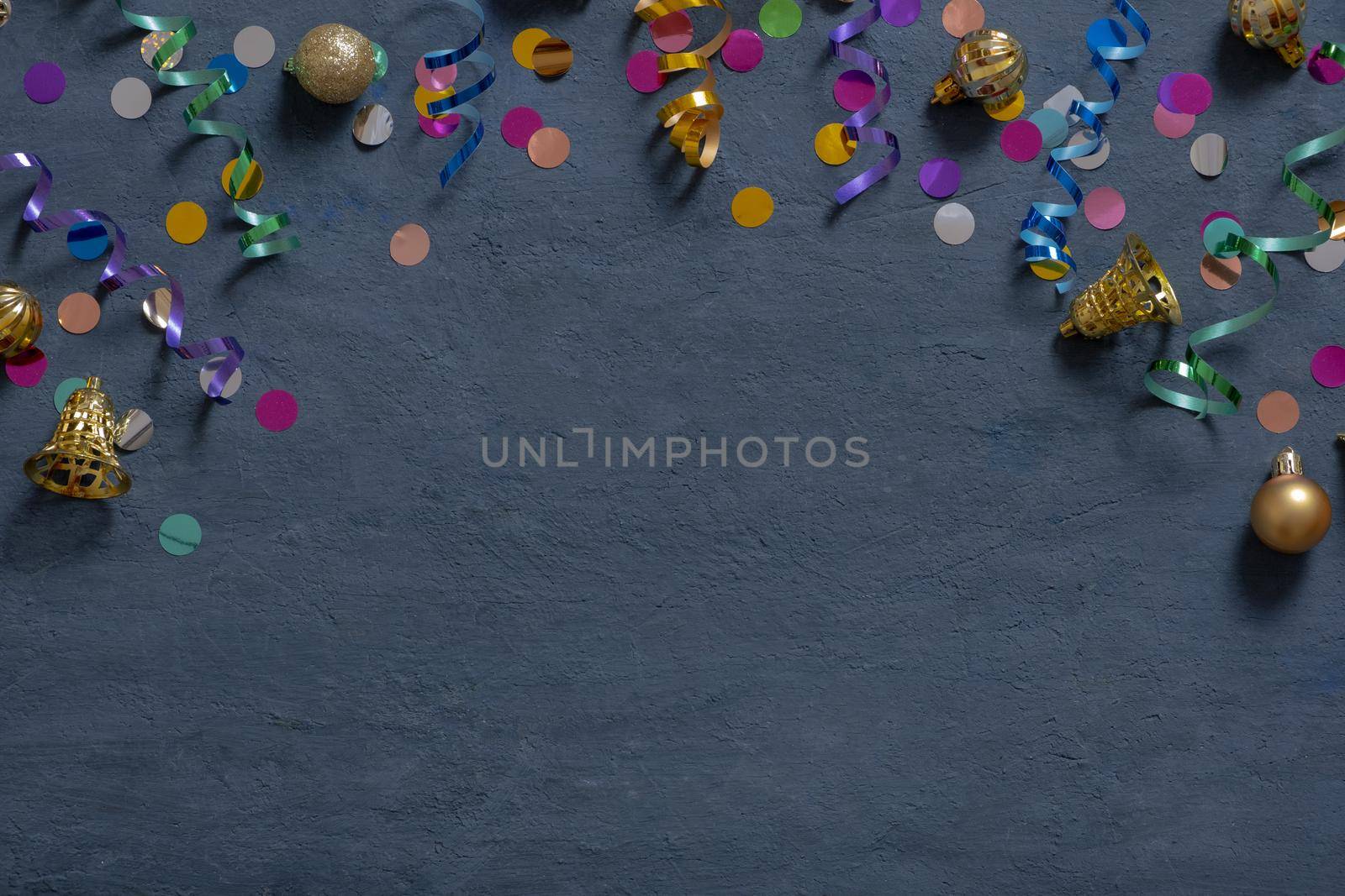 Colorful tinsel and Christmas decorations on a dark cement background with copy space by ssvimaliss