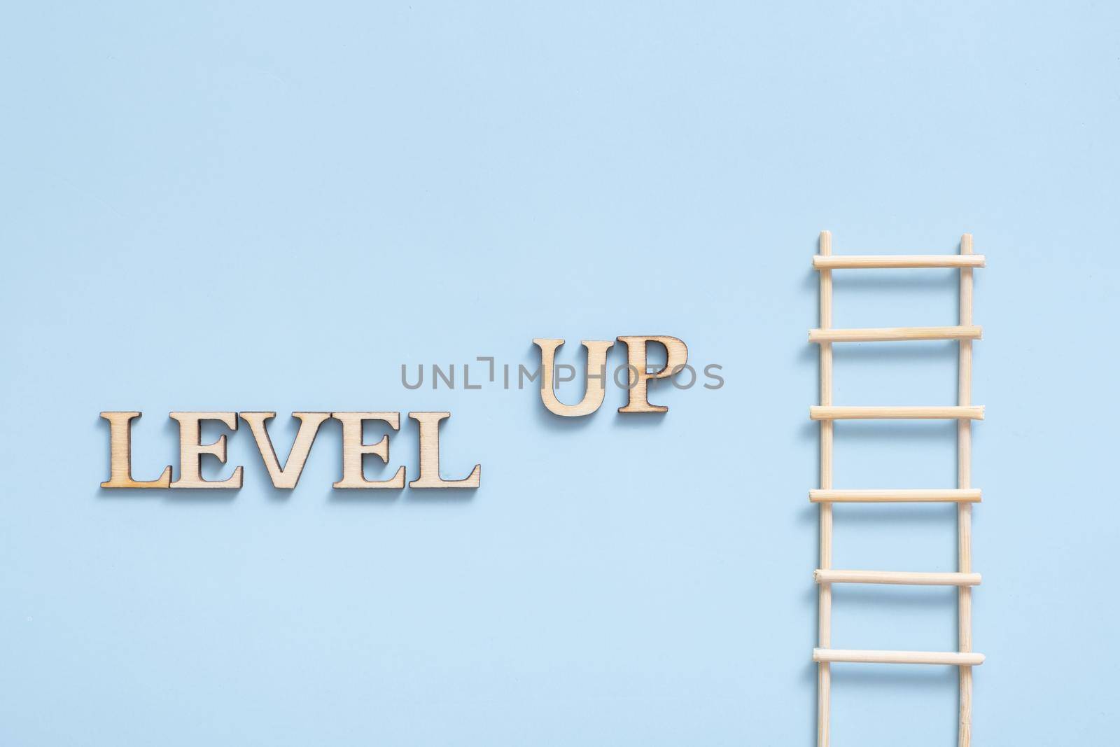 Level up wooden inscription on a colored background with grain. Achievement concept by ssvimaliss