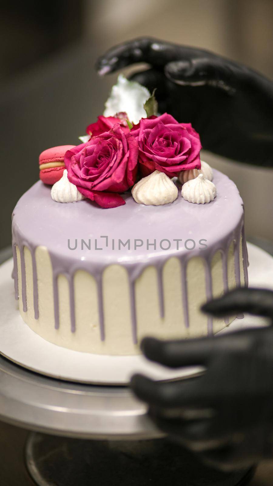 chef usign macaron , flowers and text sign for a celebration cake