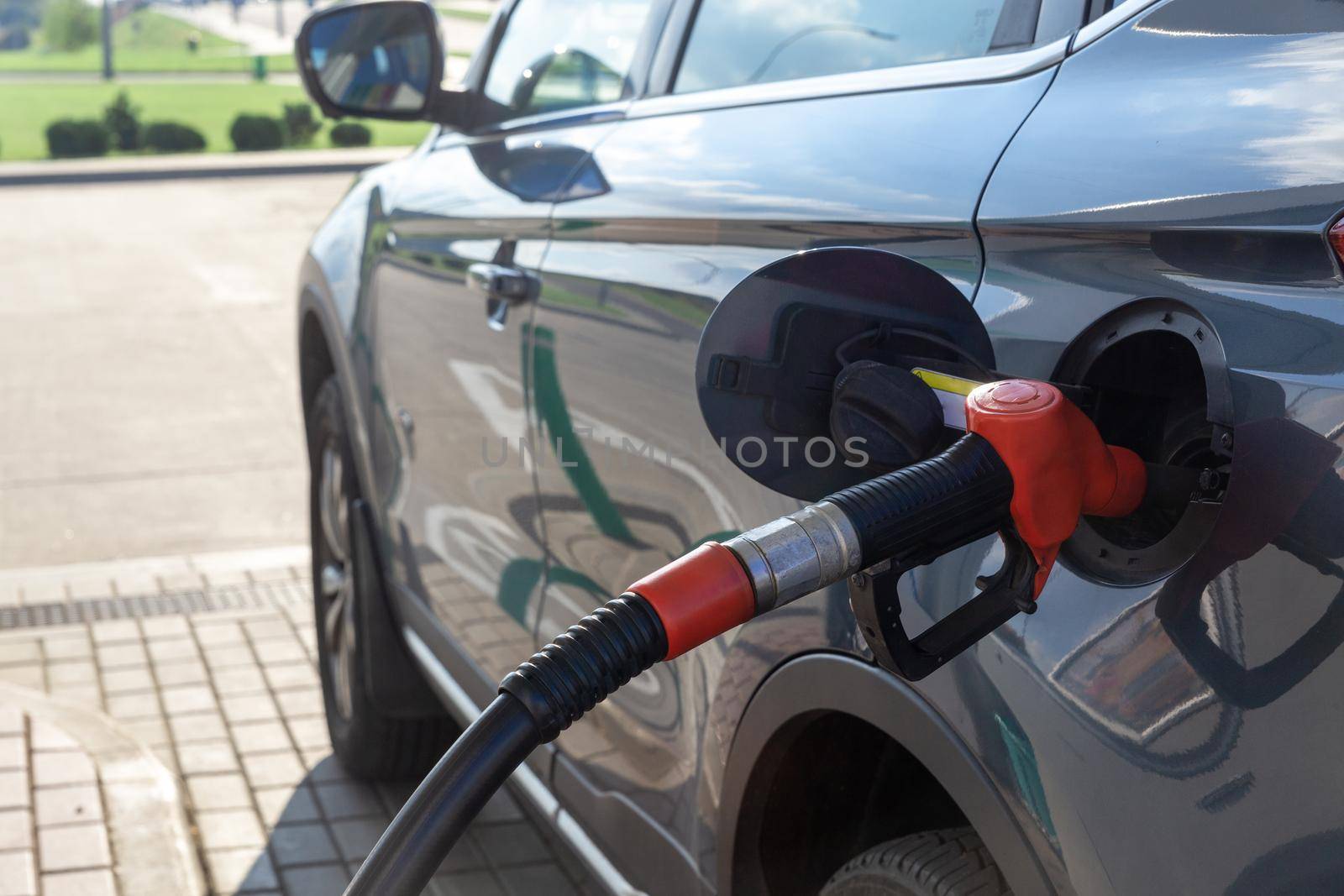 Fuel nozzle to refill fuel in car at gas station. by BY-_-BY