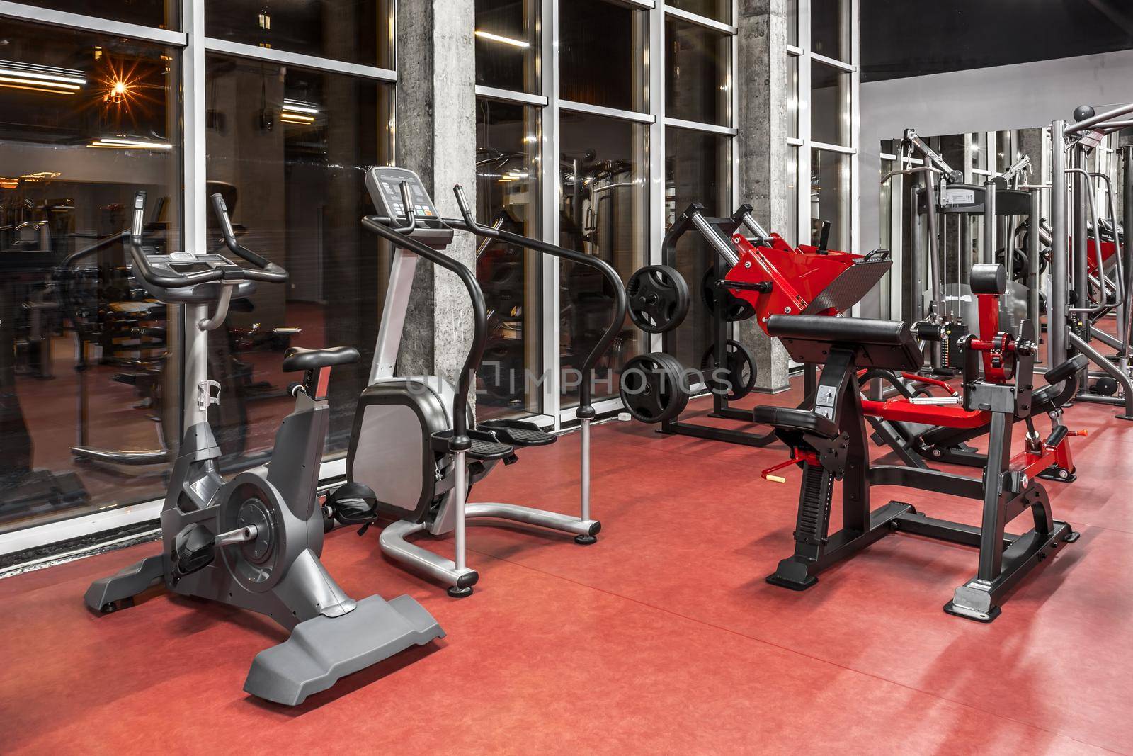 Various special equipment for physical training by the window in spacious, well lit, empty gym interior. Modern exercise machines. Sport, fitness. Healthy lifestyle concept