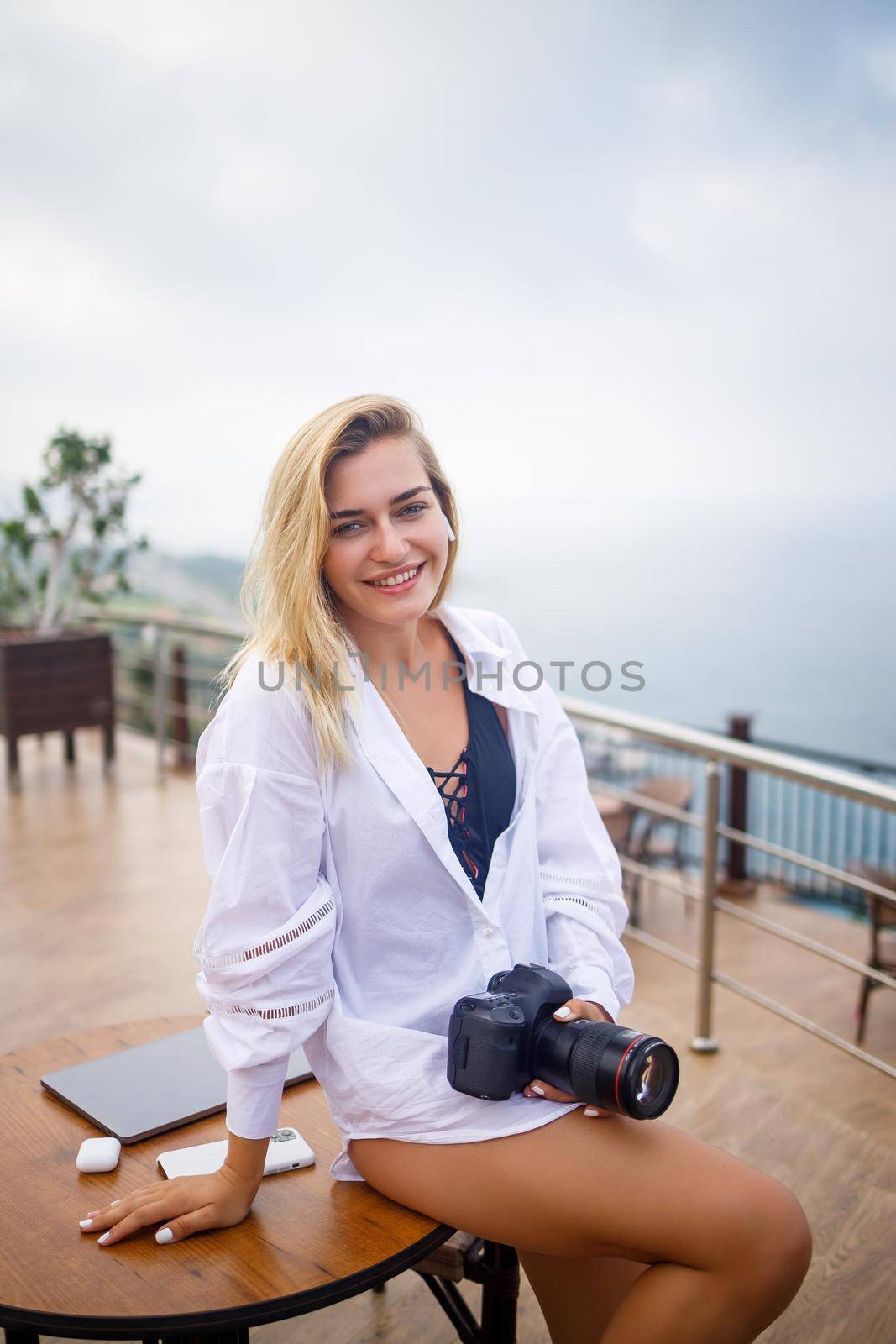 Beautiful woman photographer blogger on vacation, working with laptop by the pool. Freelance remote work by Dmitrytph
