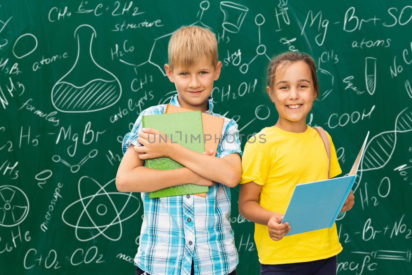 children on the background of formulas, isolated on green wall chalk board background. Childhood children kids education lifestyle concept.