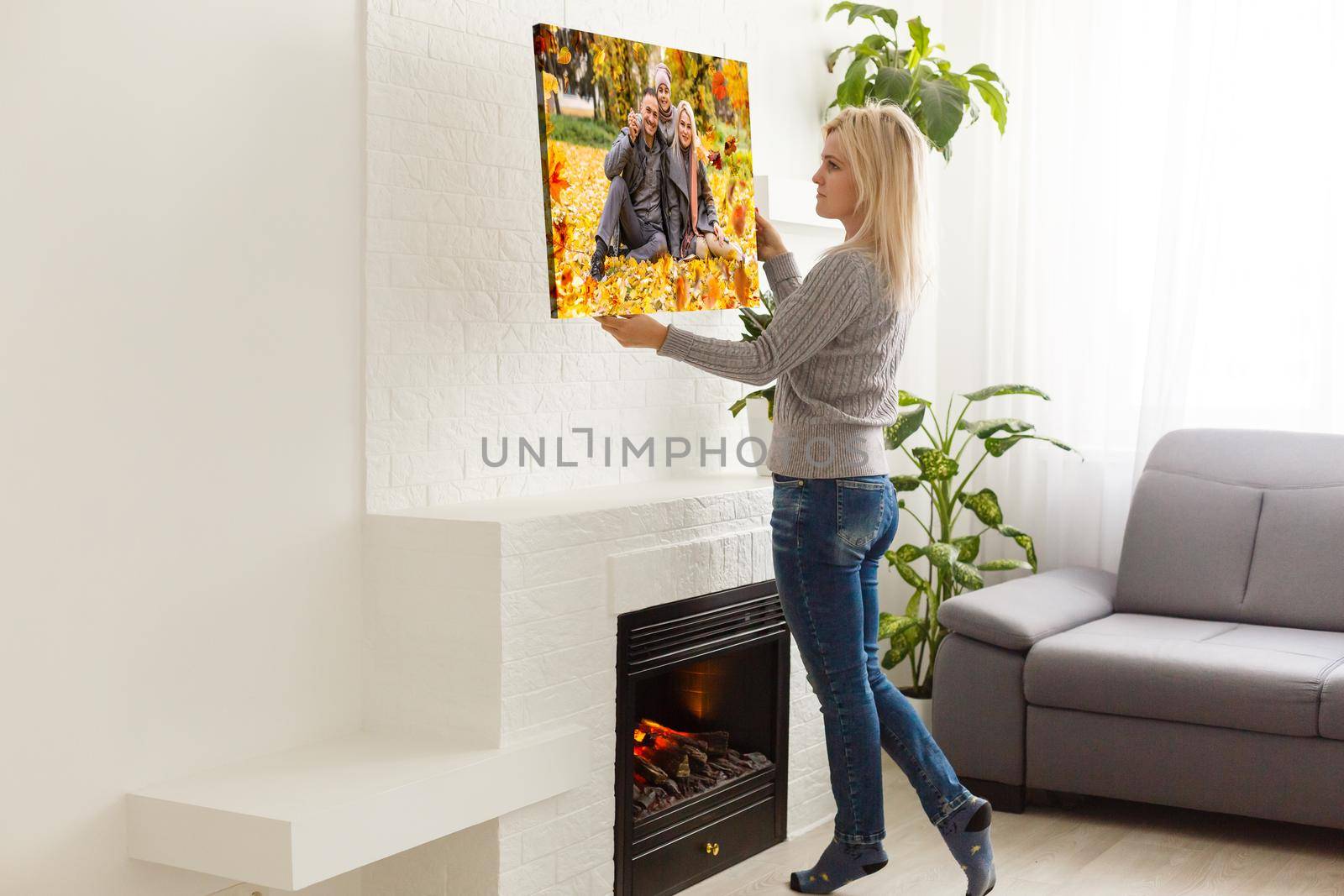 Canvas print with gallery wrap. woman hangs autumn photography, photocanvas.