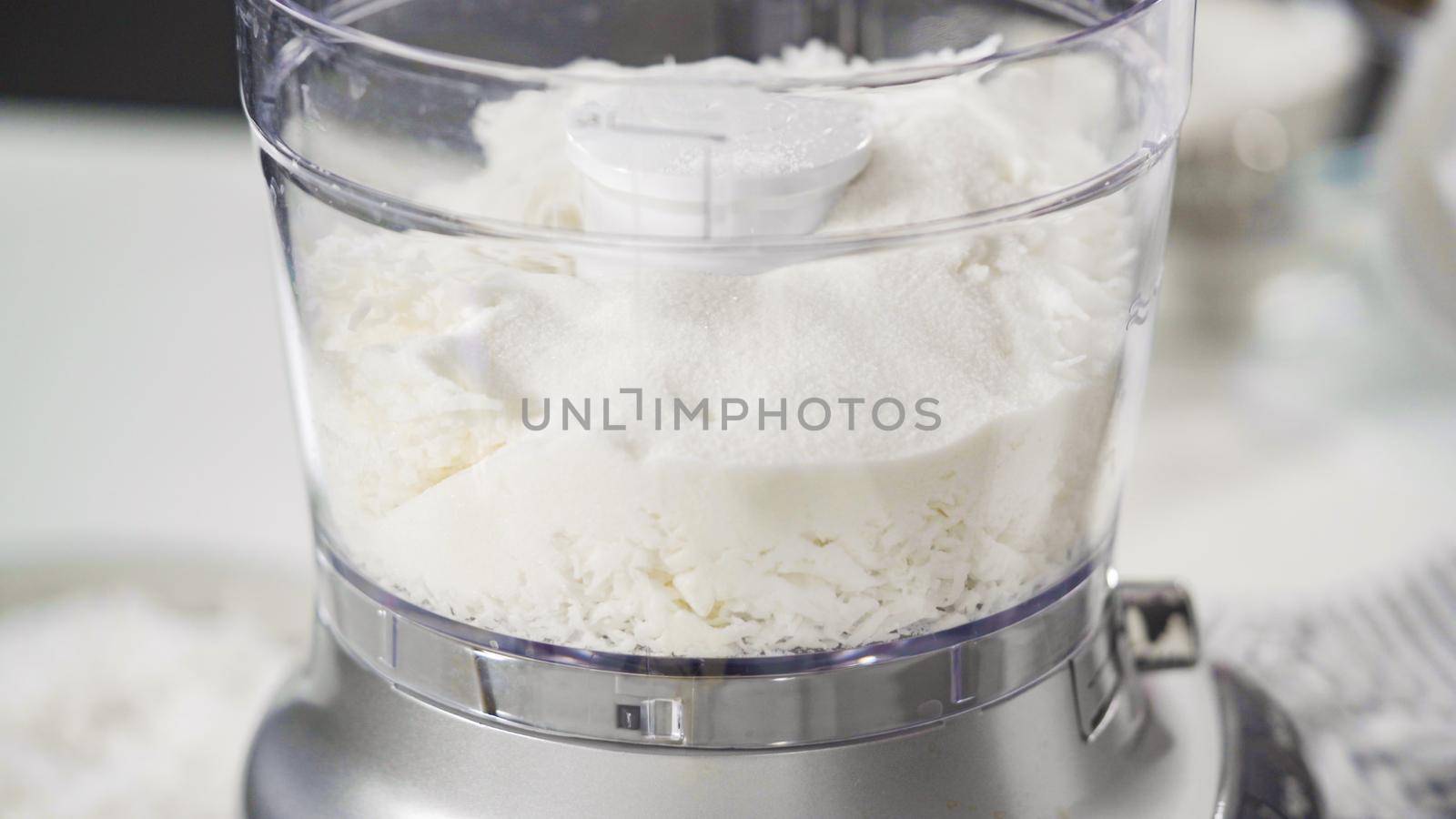 Mixing ingredients in a food processor to prepare homemade coconut cookies.
