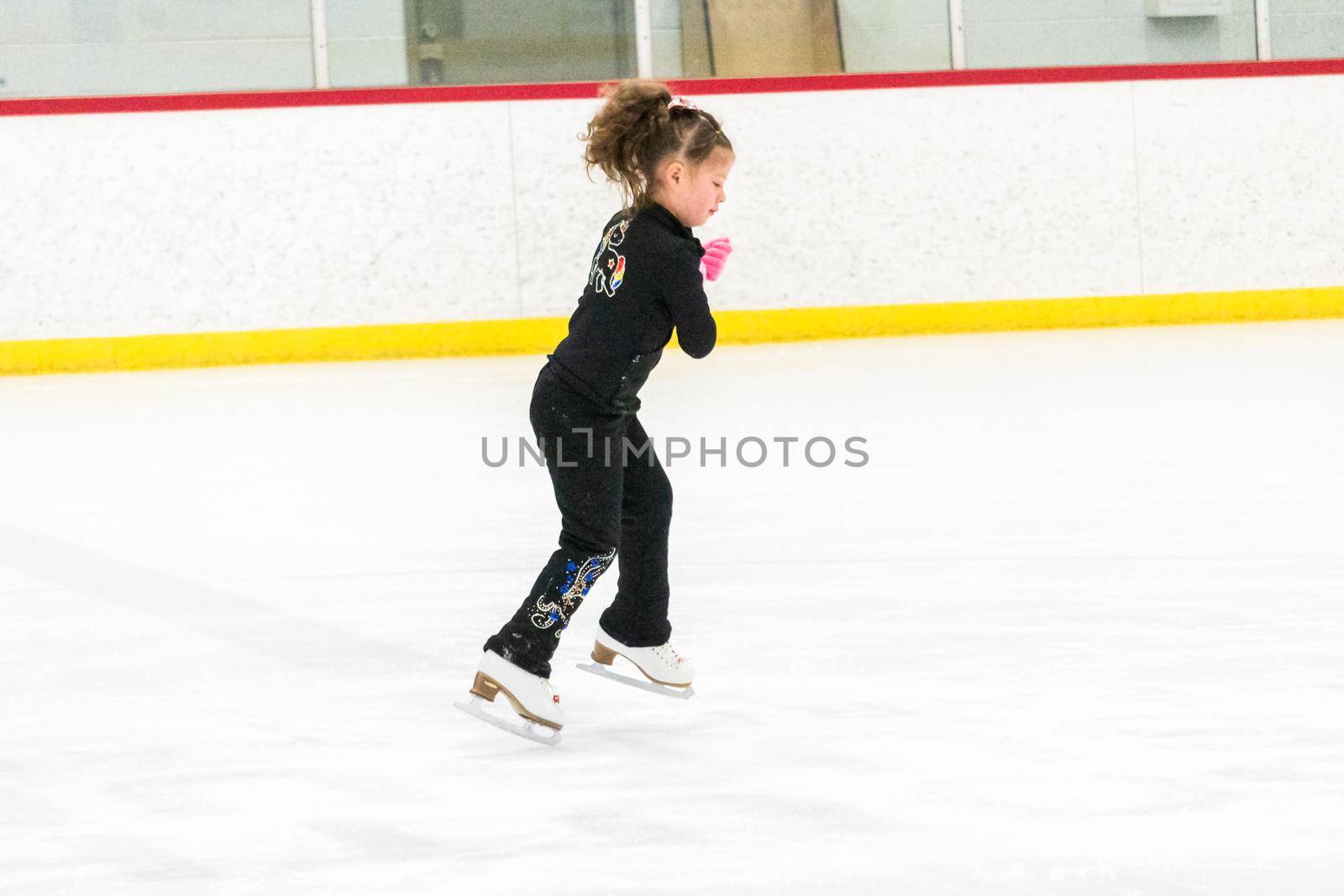 Little skater practicing her elements at the morning figure skating practice.