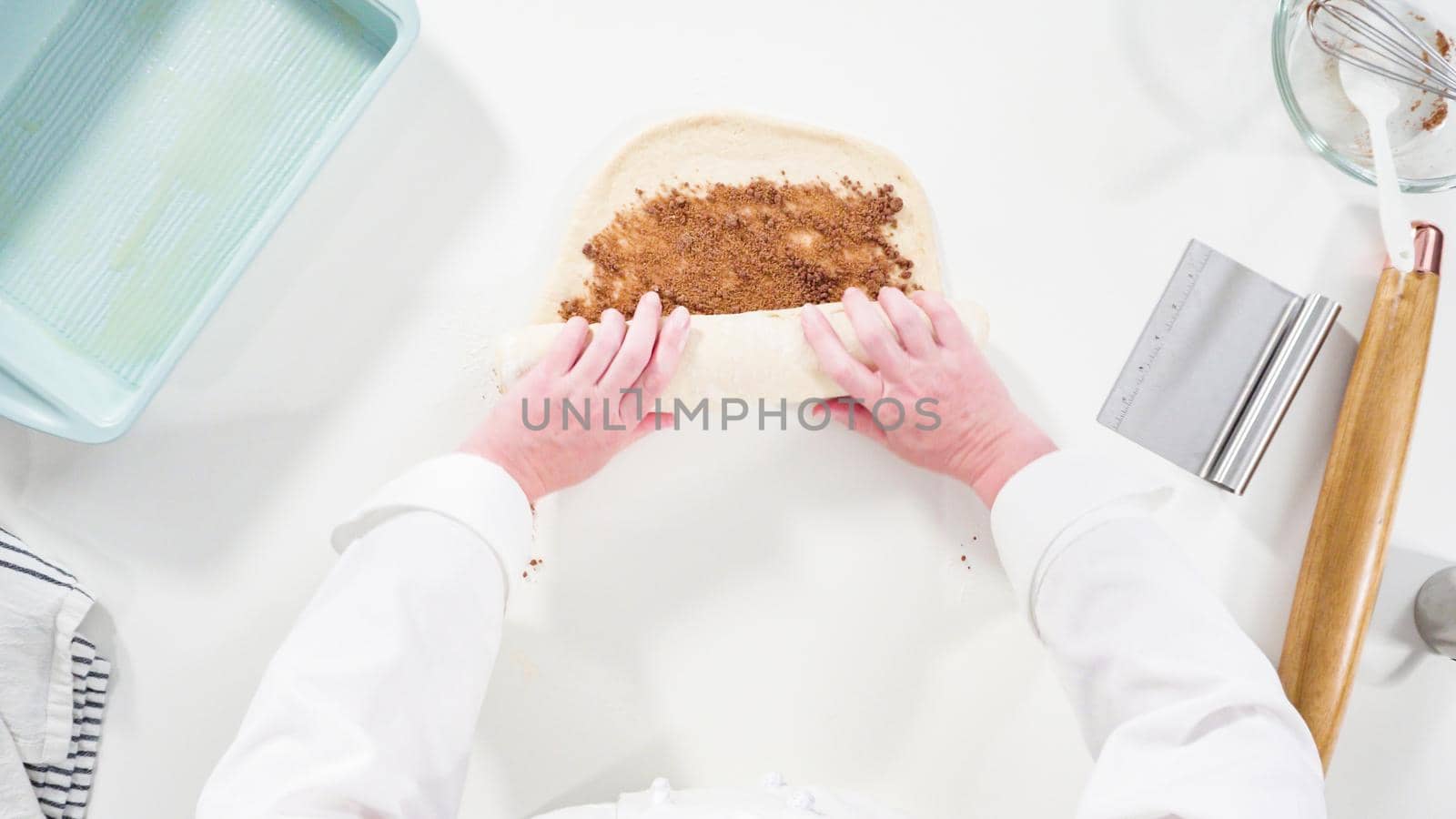 Flat lay. Rolling dough with a french rolling pin to bake cinnamon rolls.