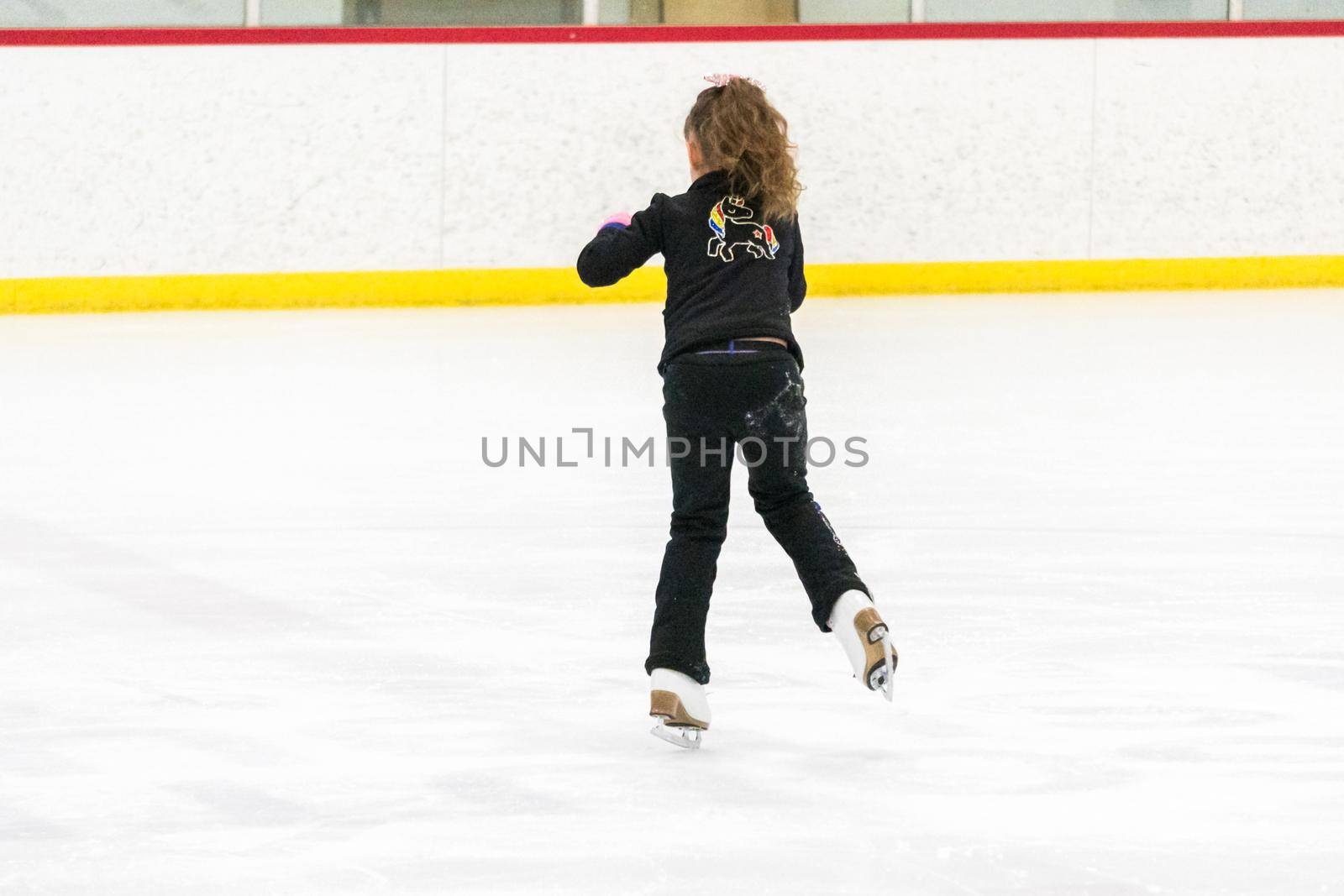 Little skater practicing her elements at the morning figure skating practice.