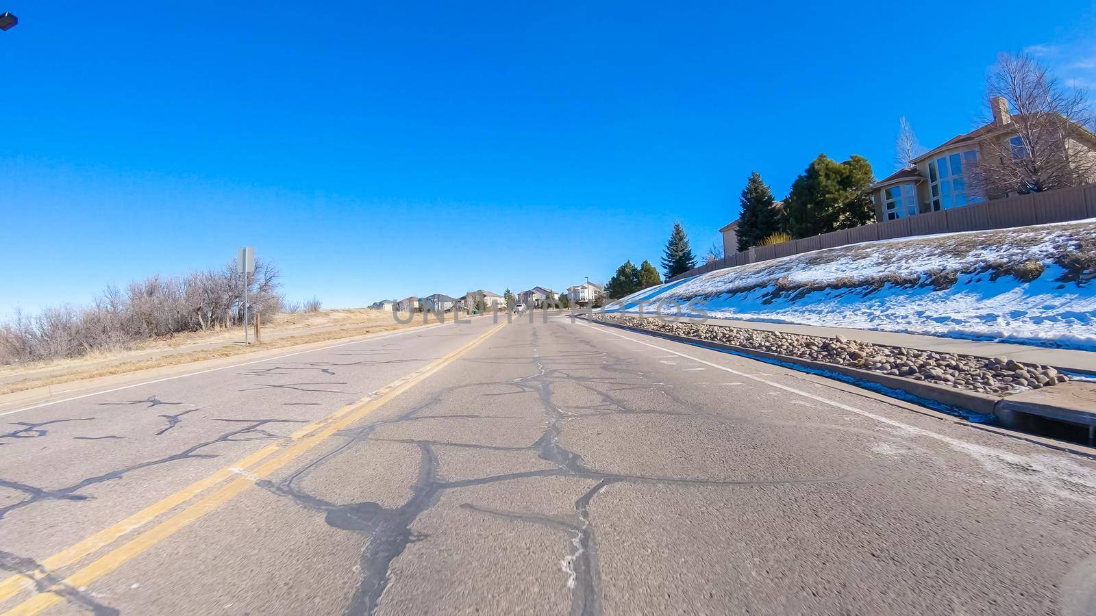 Driving on typical paved roads in a suburban upscale residential neighborhood of America.