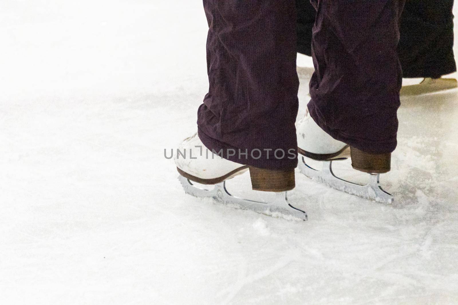 View of a figure skater and her coach feet at the figure skating practice.